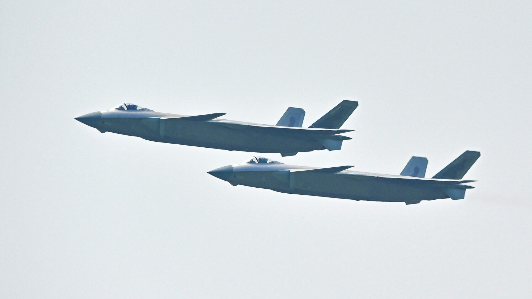 ZHUHAI, CHINA - SEPTEMBER 29: Two J-20 stealth fighter jets perform in the sky during the 13th China International Aviation and Aerospace Exhibition (Airshow China 2021) on September 29, 2021 in Zhuhai, Guangdong Province of China.