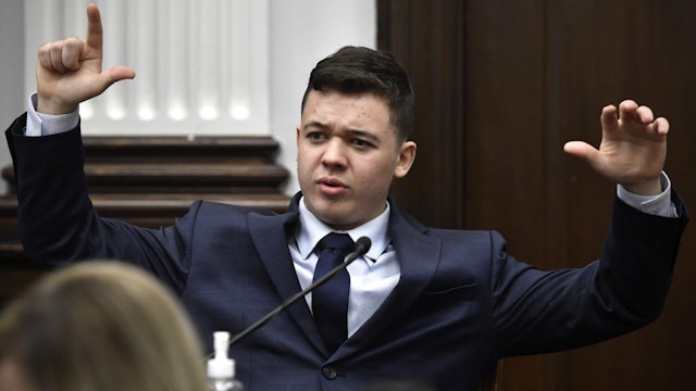 KENOSHA, WISCONSIN - NOVEMBER 10: Kyle Rittenhouse talks about how Gaige Grosskreutz was holding his gun when Rittenhouse shot him on Aug. 25, 2020, while testifying during his trial at the Kenosha County Courthouse on November 10, 2021 in Kenosha, Wisconsin. Rittenhouse is accused of shooting three demonstrators, killing two of them, during a night of unrest that erupted in Kenosha after a police officer shot Jacob Blake seven times in the back while being arrested in August 2020. Rittenhouse, from Antioch, Illinois, was 17 at the time of the shooting and armed with an assault rifle. He faces counts of felony homicide and felony attempted homicide.