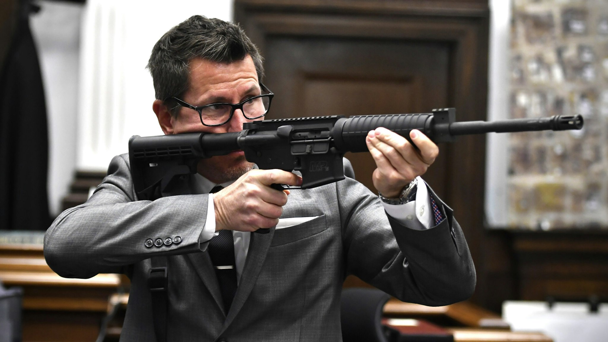 KENOSHA, WISCONSIN - NOVEMBER 15: Assistant District Attorney Thomas Binger holds Kyle Rittenhouse's gun as he gives the state's closing argument in Kyle Rittenhouse's trial at the Kenosha County Courthouse on November 15, 2021 in Kenosha, Wisconsin. Rittenhouse is accused of shooting three demonstrators, killing two of them, during a night of unrest that erupted in Kenosha after a police officer shot Jacob Blake seven times in the back while being arrested in August 2020. Rittenhouse, from Antioch, Illinois, was 17 at the time of the shooting and armed with an assault rifle. He faces counts of felony homicide and felony attempted homicide.