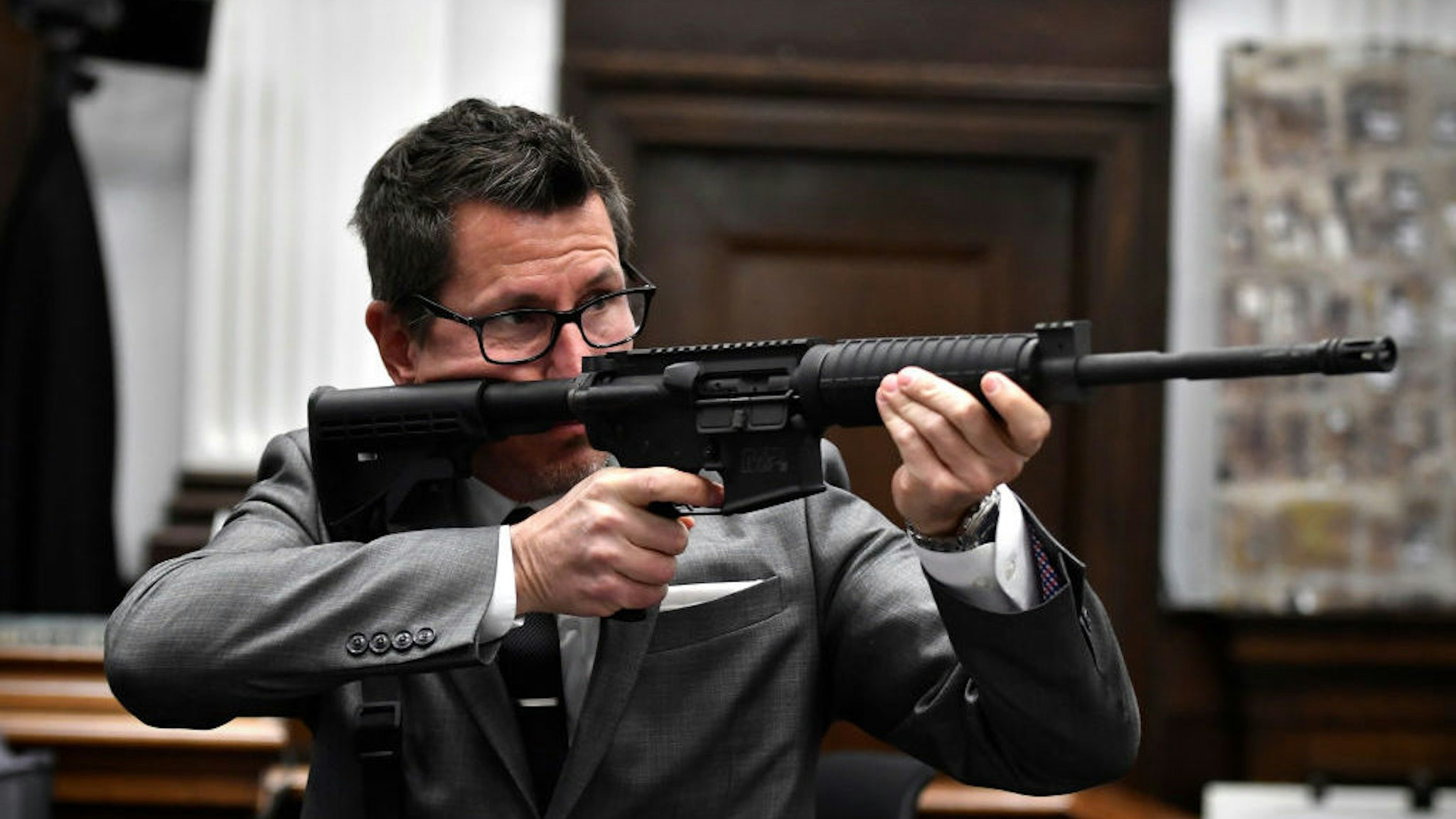KENOSHA, WISCONSIN - NOVEMBER 15: Assistant District Attorney Thomas Binger holds Kyle Rittenhouse's gun as he gives the state's closing argument in Kyle Rittenhouse's trial at the Kenosha County Courthouse on November 15, 2021 in Kenosha, Wisconsin. Rittenhouse is accused of shooting three demonstrators, killing two of them, during a night of unrest that erupted in Kenosha after a police officer shot Jacob Blake seven times in the back while being arrested in August 2020. Rittenhouse, from Antioch, Illinois, was 17 at the time of the shooting and armed with an assault rifle. He faces counts of felony homicide and felony attempted homicide. (Photo by Sean Krajacic-Pool/Getty Images)
