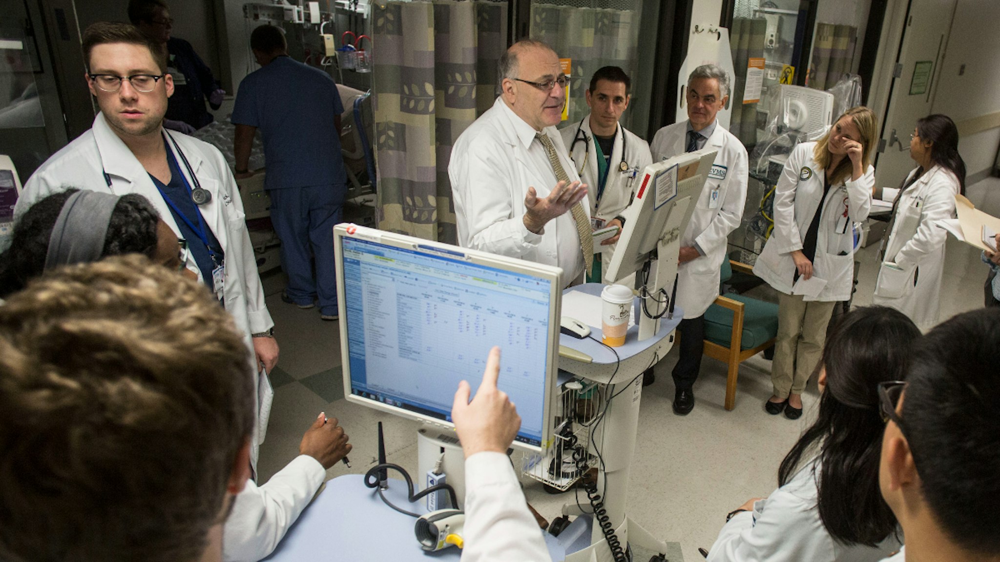 Dr. Paul Marik, center, discusses patient care with medical students and resident physicians during morning rounds at Sentara Norfolk General hospital on Monday, Oct. 20, 2014 in Norfolk, Va. (Photo by Jay Westcott/For The Washington Post via Getty Images)