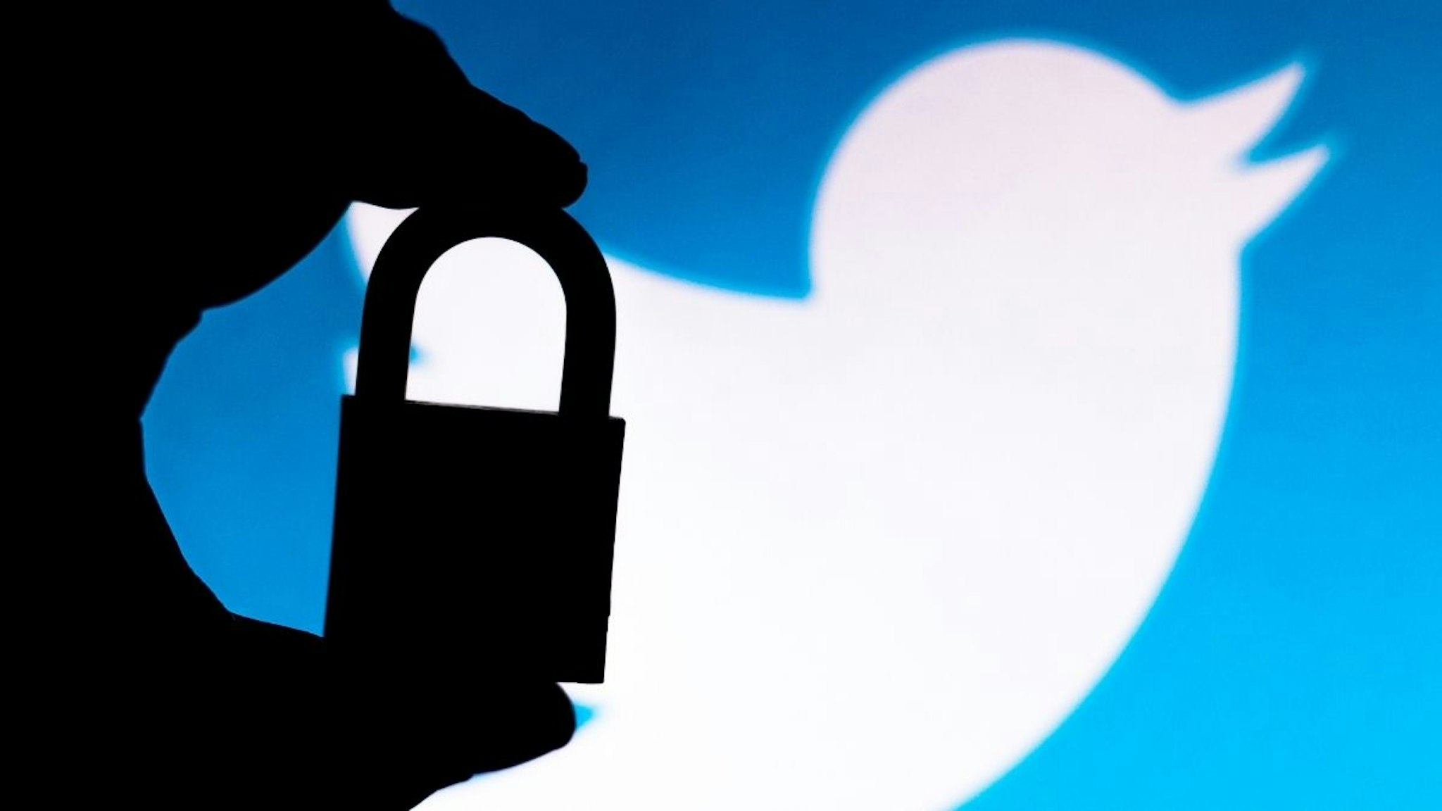 In this photo illustration a padlock appears next to the Twitter logo.