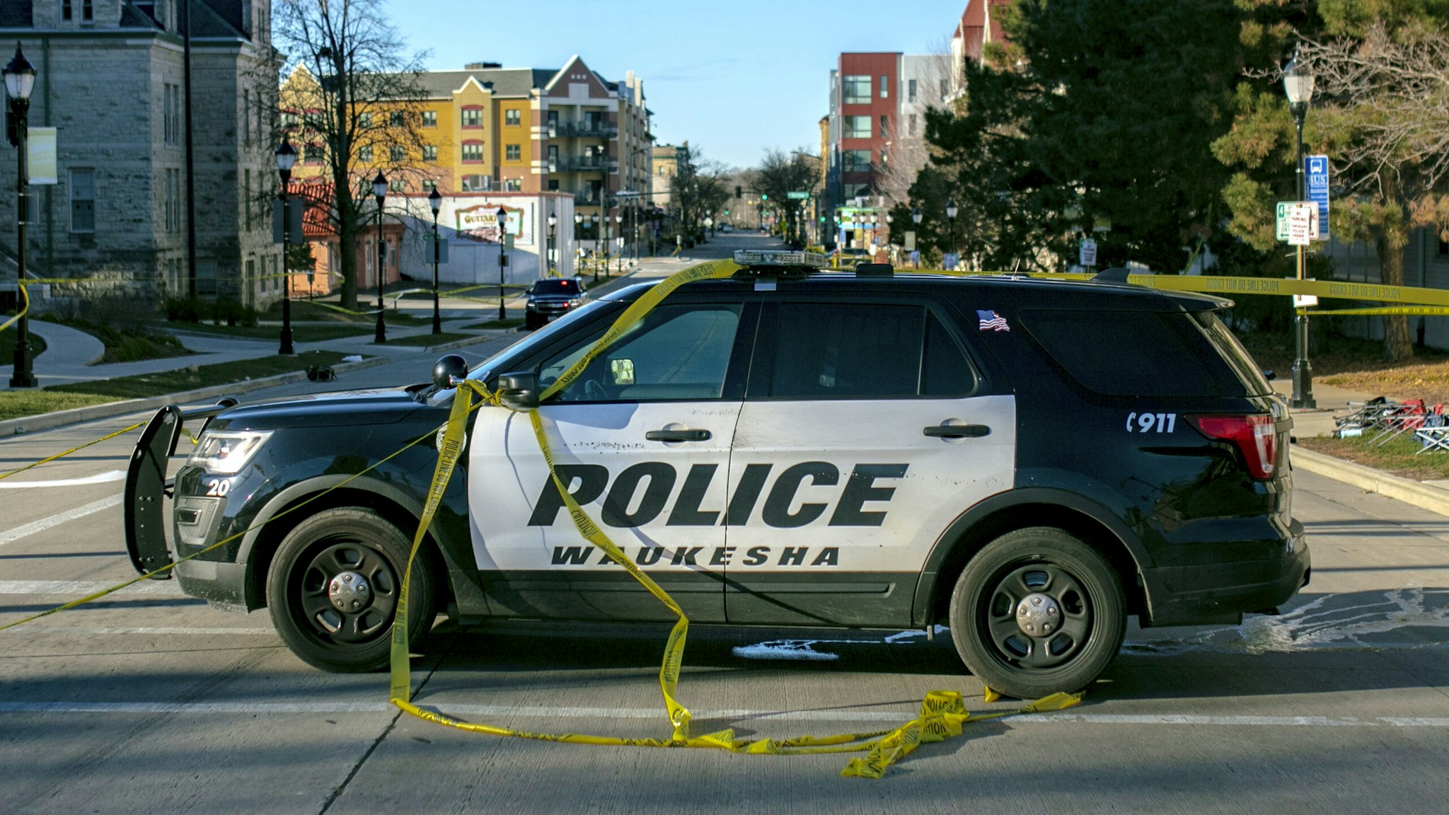 WAUKESHA, WI - NOVEMBER 22: Police block off road entrances following a driver plowing into the Christmas parade on Main Street in downtown November 22, 2021 in Waukesha, Wisconsin. Five people were left dead after a person driving an S.U.V. entered the parade route and proceeded to strike dozens of people.