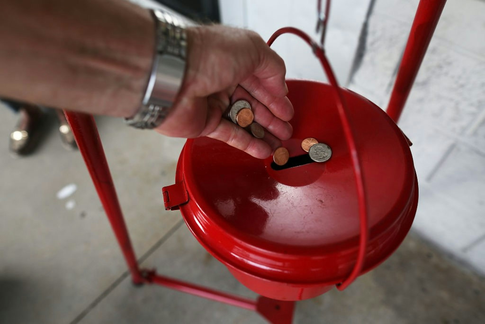 HALLANDALE, FL - NOVEMBER 28: A donation is made into a Salvation Army red kettle on Giving Tuesday on November 28, 2017 in Hallandale, Florida. Giving Tuesday is a single day following the heavy Thanksgiving shopping period specifically focused on charity. (Photo by