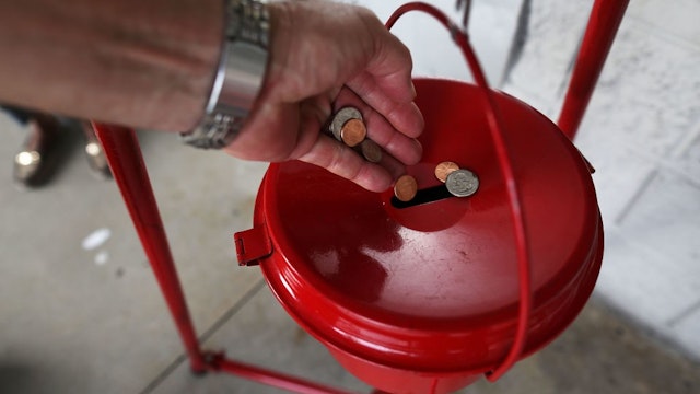 HALLANDALE, FL - NOVEMBER 28: A donation is made into a Salvation Army red kettle on Giving Tuesday on November 28, 2017 in Hallandale, Florida. Giving Tuesday is a single day following the heavy Thanksgiving shopping period specifically focused on charity. (Photo by
