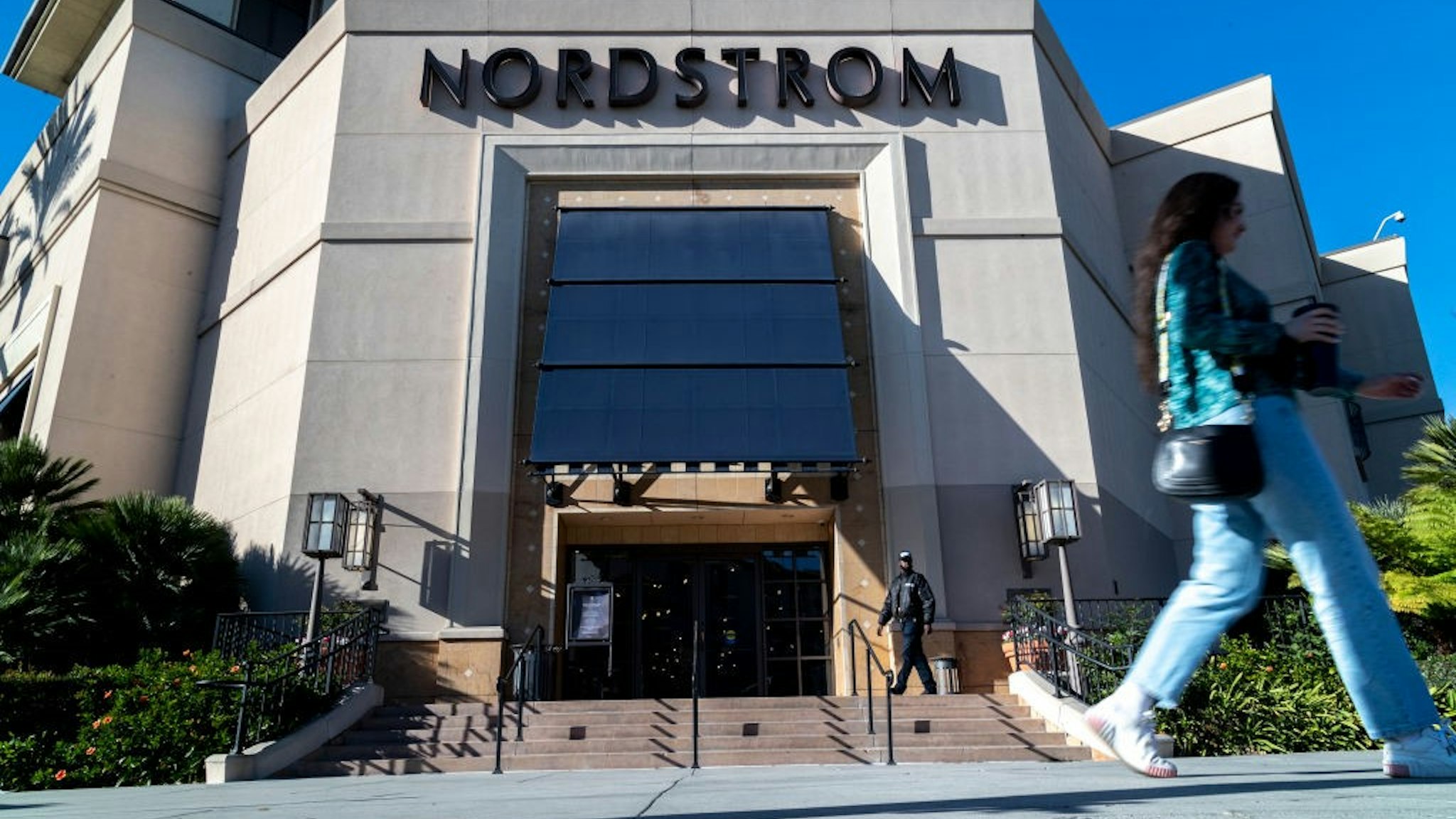 LOS ANGELES, CA - NOVEMBER 23, 2021: A security guard patrols the front entrance of Nordstrom on Tuesday after an organized group of thieves attempted a smash-and-grab robbery late Monday night at The Grove location November 23, 20201 in Los Angeles, California.