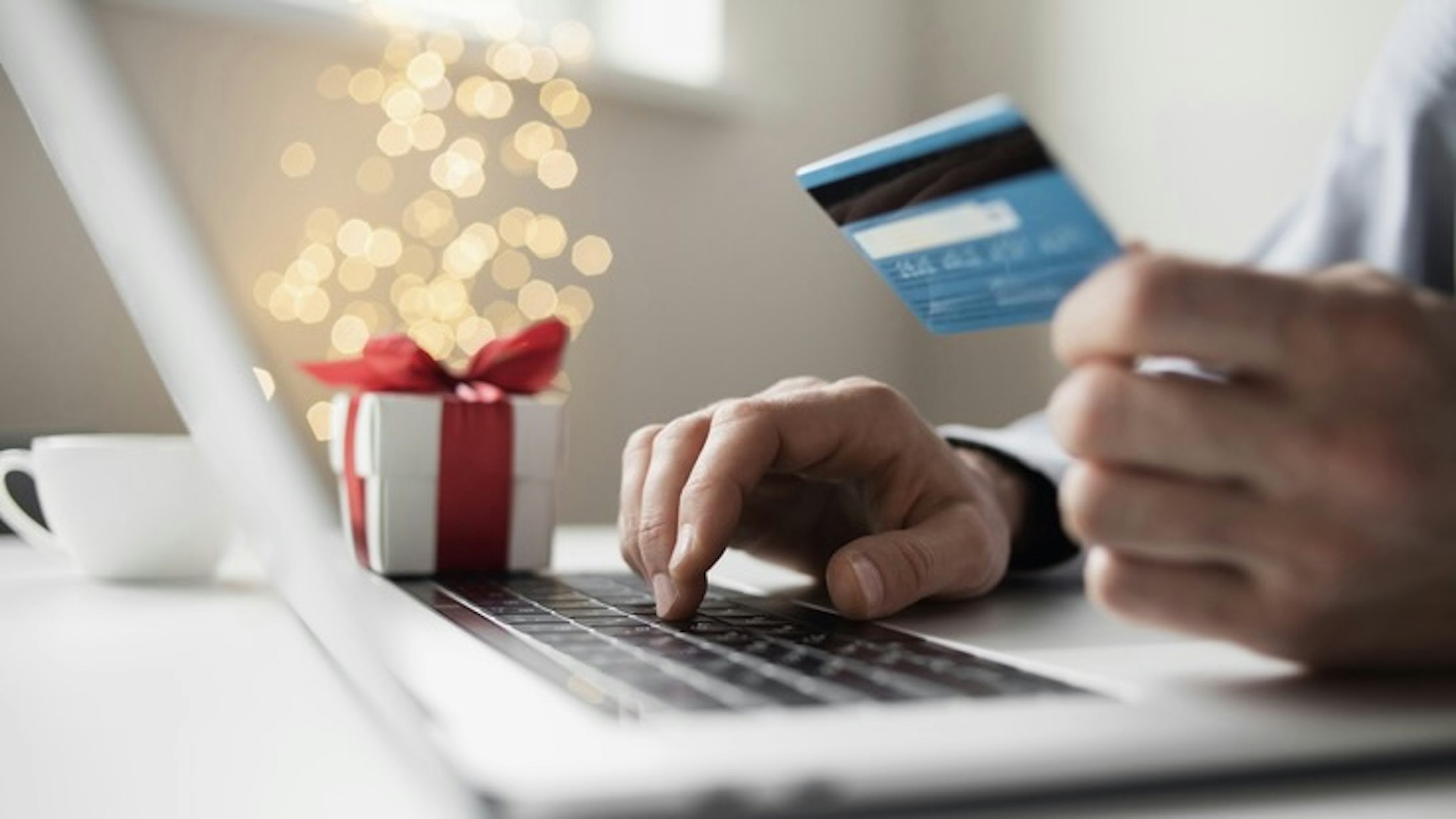 Online shopping during holidays. Man ordering Christmas gift using laptop and credit card - stock photo Ordering Christmas presents, online payment. Online shopping, internet banking, spending money, holidays, vacations concept Poike via Getty Images