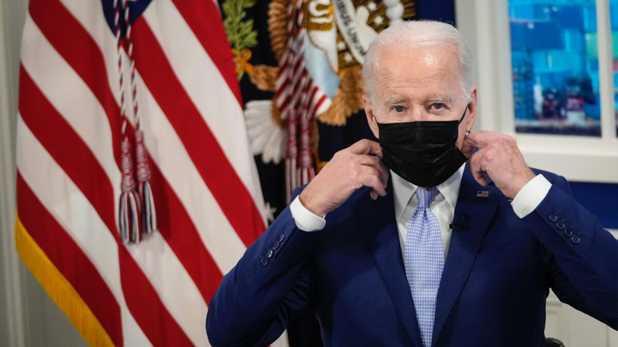 U.S. President Joe Biden removes his mask before speaking during a meeting with his administration's Supply Chain Disruptions Task Force and private sector CEOs in the South Court Auditorium of the White House December 22, 2021 in Washington, DC.