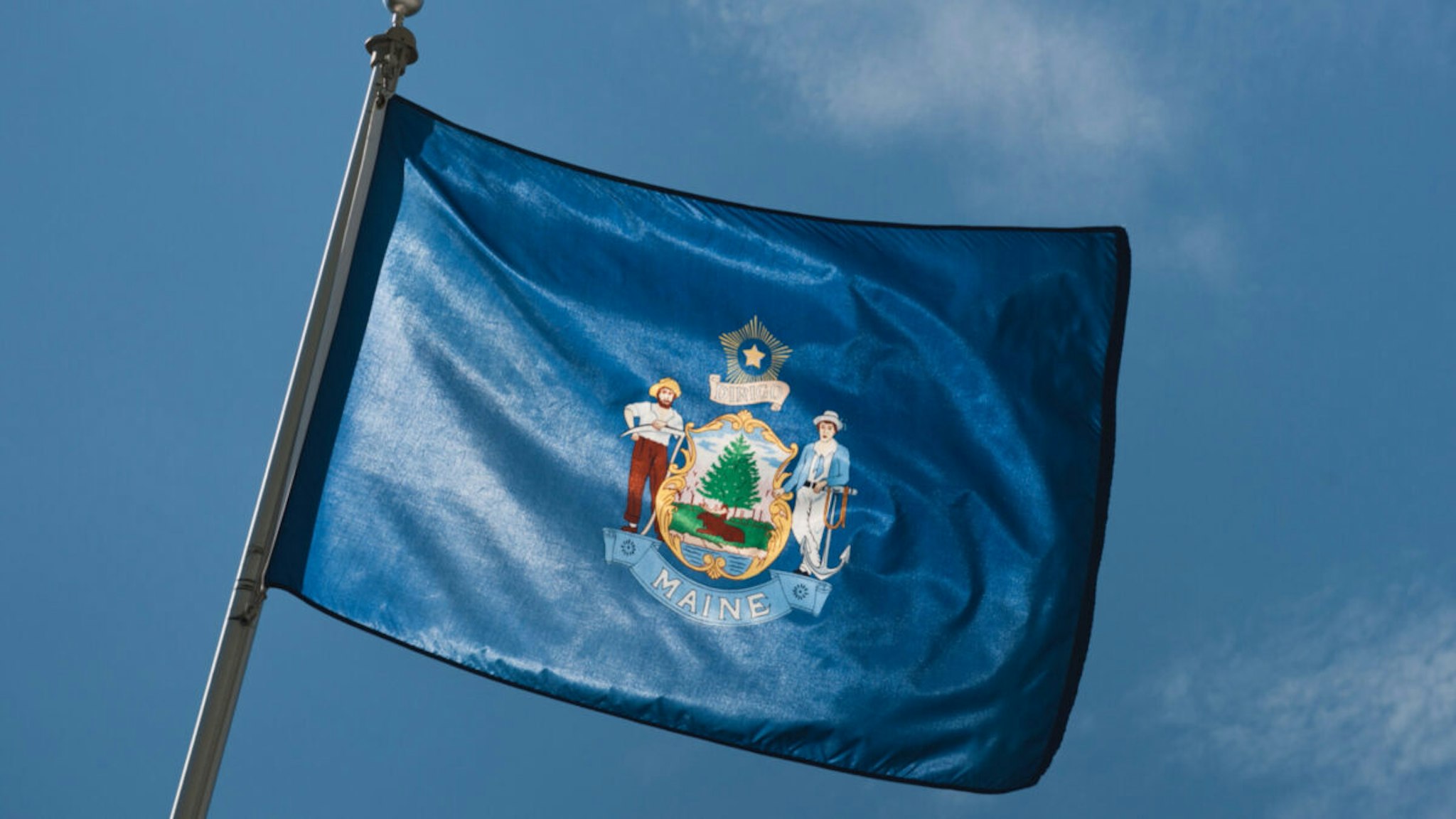 Maine State flag against sky - stock photo.