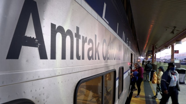 Amtrak May Reduce Long-Distance Service Due To Unvaccinated Workers LOS ANGELES, CALIFORNIA - DECEMBER 09: A passenger boards an Amtrak train at Union Station on December 9, 2021 in Los Angeles, California. Amtrak is having difficulty hiring and retaining employees as a nationwide labor shortage has left the national intercity rail carrier down 1,500 workers since the beginning of the pandemic. The railroad is set to terminate unvaccinated workers on January 4th which may force them to reduce the frequency of long-distance service. (Photo by Mario Tama/Getty Images) Mario Tama / Staff