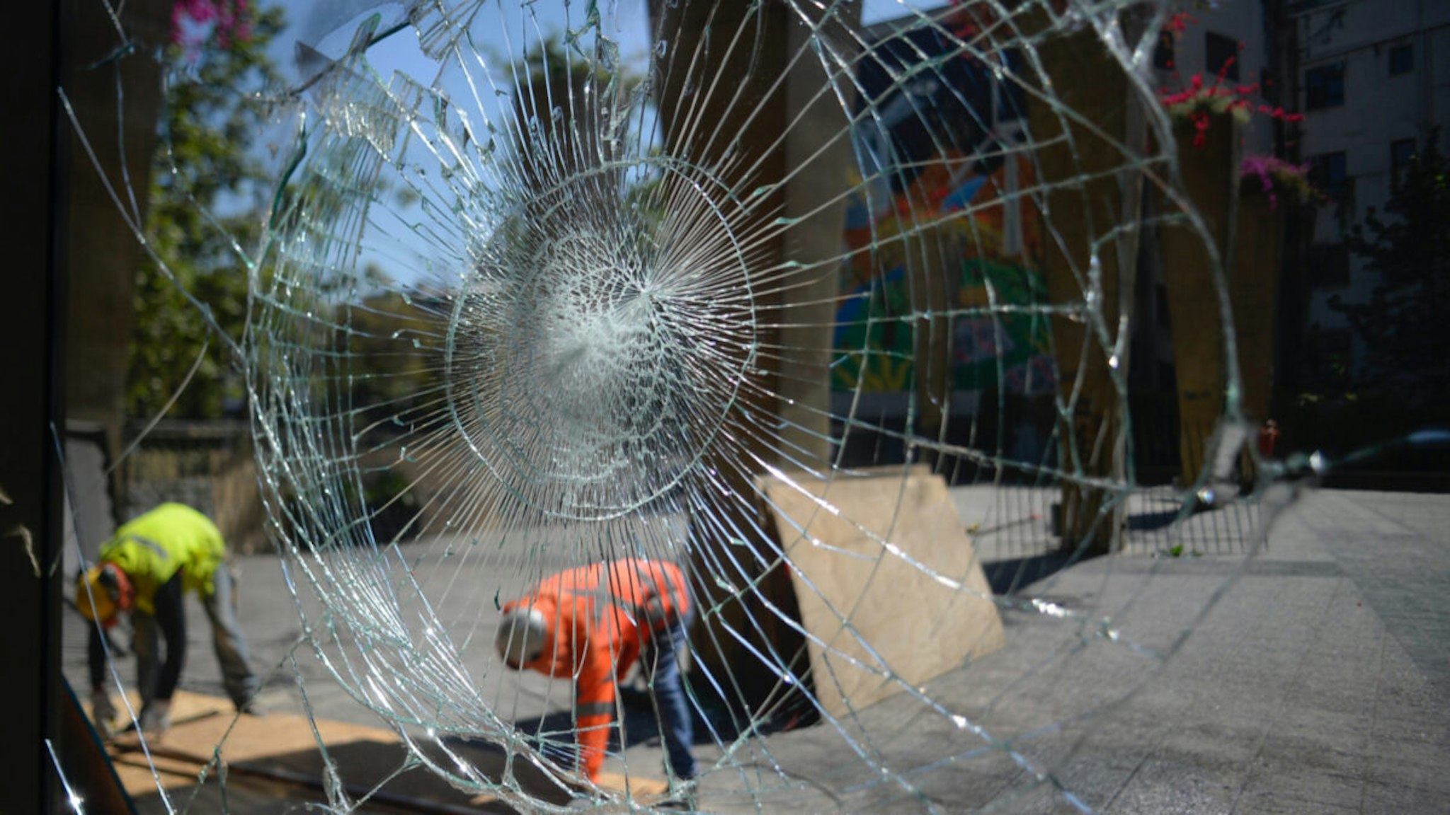 Workers repair a looted restaurant during the seventh day of protests against President Sebastian Piñera on October 24, 2019 in Santiago, Chile.