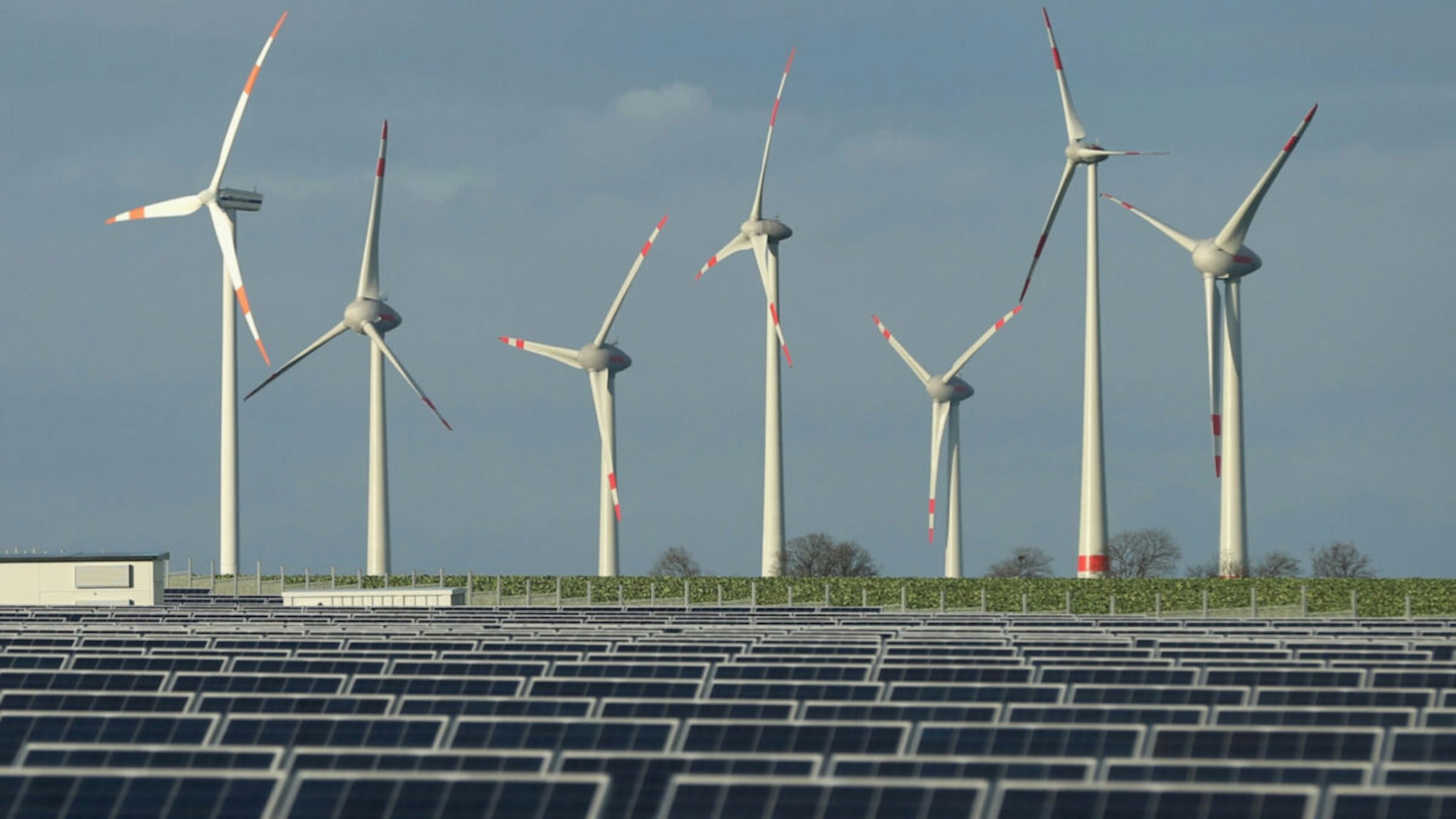 Wind turbines stand behind a solar power park on October 30, 2013 near Werder, Germany.