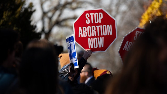 A demonstrator holds a "Stop Abortion Now" sign outside the U.S. Supreme Court in Washington, D.C., U.S., on Wednesday, Dec. 1, 2021.