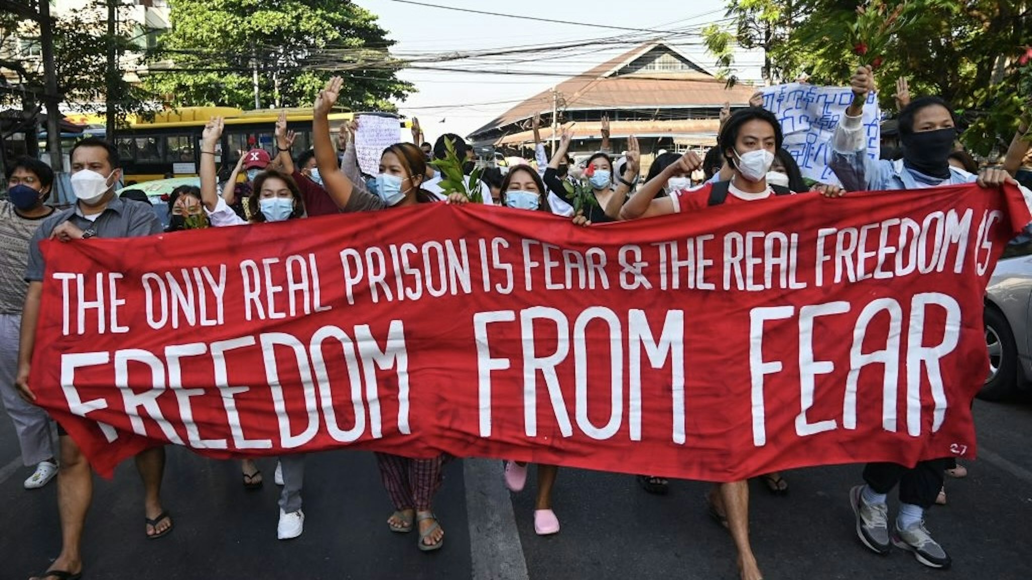 MYANMAR-POLITICS-MILITARY Protesters hold a banner as they take part in a demonstration against the military coup in Yangon December 5, 2021. (Photo by AFP) (Photo by STR/AFP via Getty Images) STR / Contributor