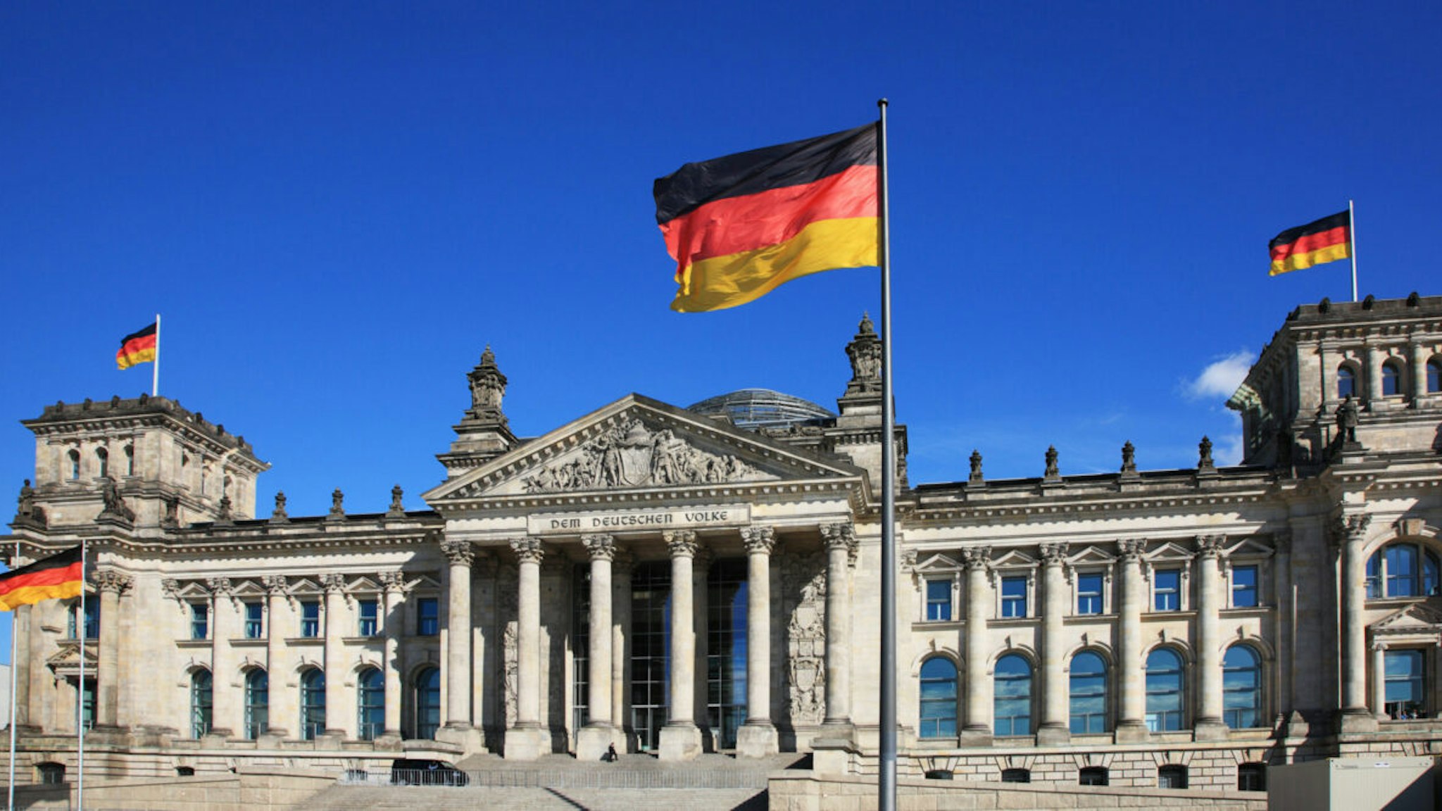 Germany, Berlin, Reichstag, the Parliament Building and national flag via Getty Images