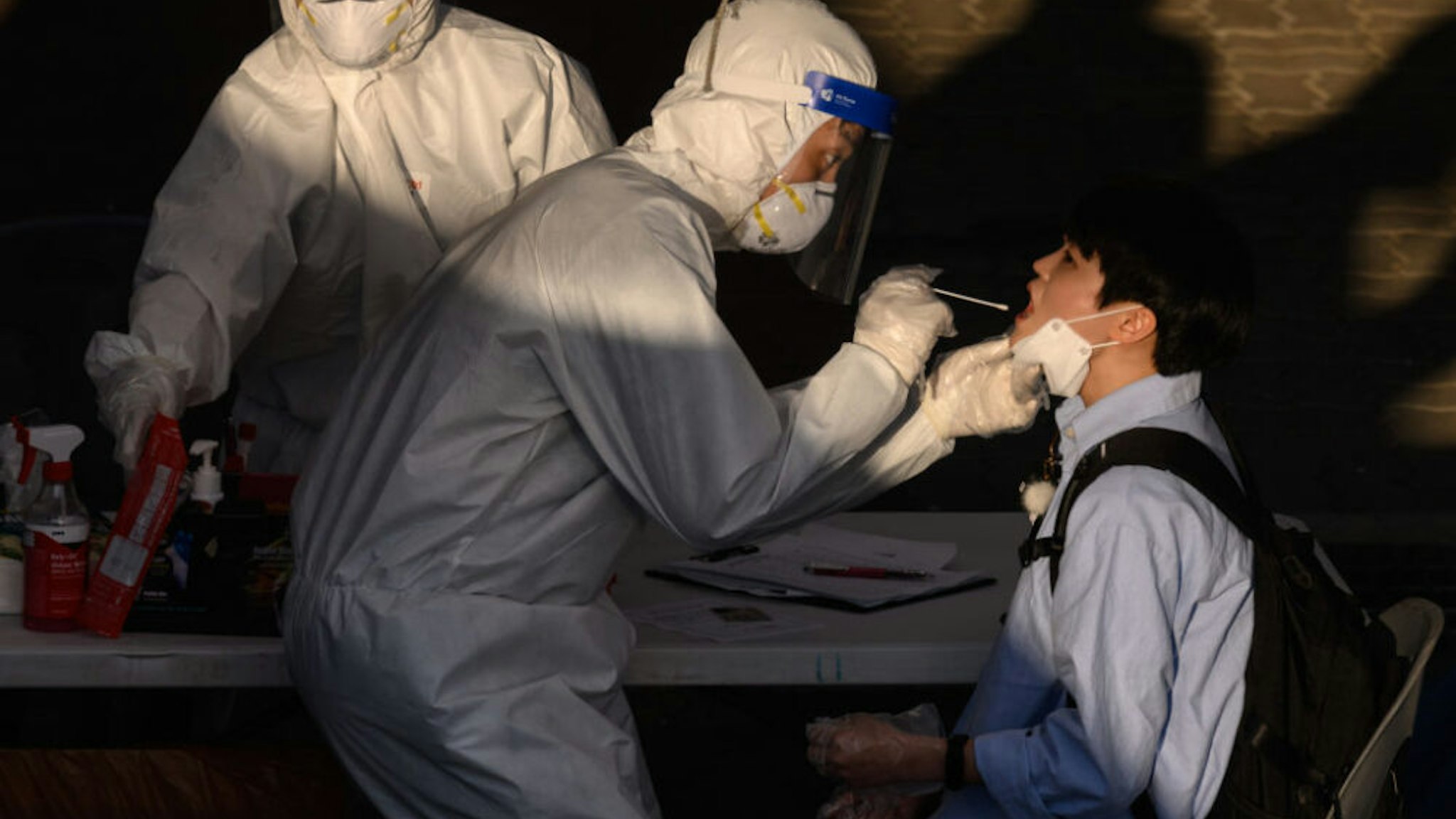 TOPSHOT - A health worker administers a swab at a temporary COVID-19 novel coronavirus testing centre in Bucheon, south of Seoul, on May 27, 2020. - South Korea reported its biggest jump in coronavirus infections in seven weeks on May 27, driven by a fresh cluster at an e-commerce warehouse on Seoul's outskirts, as millions more pupils went back to school.