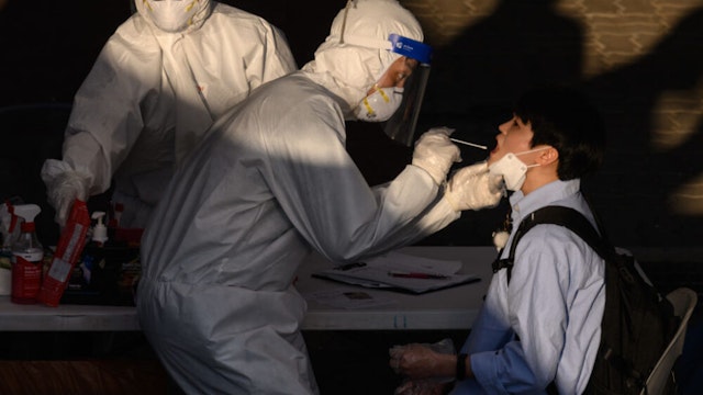 TOPSHOT - A health worker administers a swab at a temporary COVID-19 novel coronavirus testing centre in Bucheon, south of Seoul, on May 27, 2020. - South Korea reported its biggest jump in coronavirus infections in seven weeks on May 27, driven by a fresh cluster at an e-commerce warehouse on Seoul's outskirts, as millions more pupils went back to school.