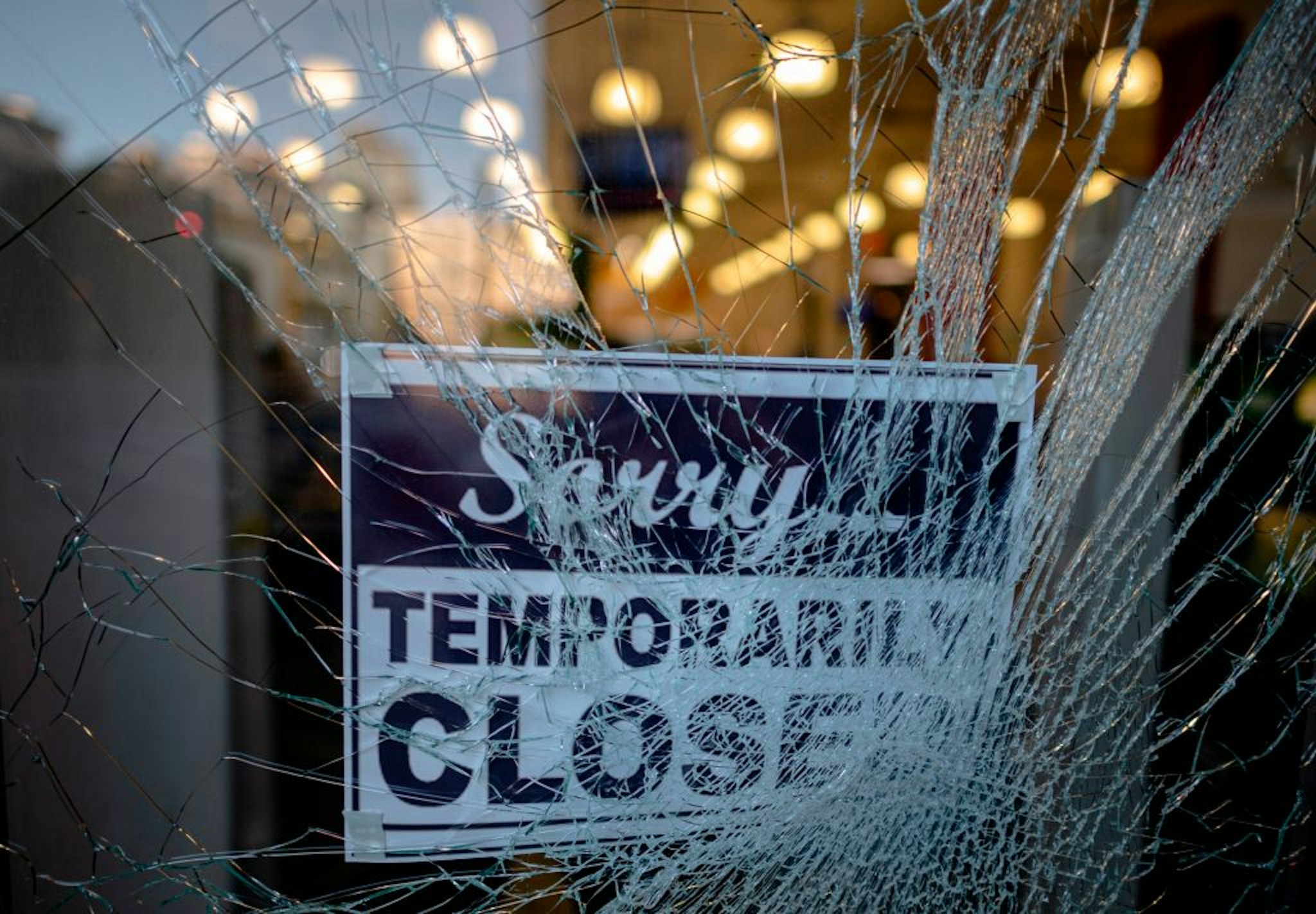 A sign reading "sorry temporarily closed" is seen behind a shattered glass of a storefront after a night of protest over the death of African-American man George Floyd in Minneapolis on June 1, 2020 in Lower Manhattan in New York City. - Thousands of National Guard troops patrolled major US cities after five consecutive nights of protests over racism and police brutality that boiled over into arson and looting, sending shock waves through the country. The death Monday of an unarmed black man, George Floyd, at the hands of police in Minneapolis ignited this latest wave of outrage in the US over law enforcement's repeated use of lethal force against African Americans -- this one like others before captured on cellphone video. (Photo by Johannes EISELE / AFP) (Photo by JOHANNES EISELE/AFP via Getty Images)