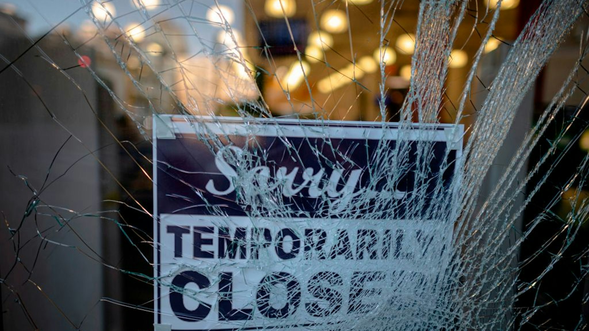 A sign reading "sorry temporarily closed" is seen behind a shattered glass of a storefront after a night of protest over the death of African-American man George Floyd in Minneapolis on June 1, 2020 in Lower Manhattan in New York City. - Thousands of National Guard troops patrolled major US cities after five consecutive nights of protests over racism and police brutality that boiled over into arson and looting, sending shock waves through the country. The death Monday of an unarmed black man, George Floyd, at the hands of police in Minneapolis ignited this latest wave of outrage in the US over law enforcement's repeated use of lethal force against African Americans -- this one like others before captured on cellphone video. (Photo by Johannes EISELE / AFP) (Photo by JOHANNES EISELE/AFP via Getty Images)