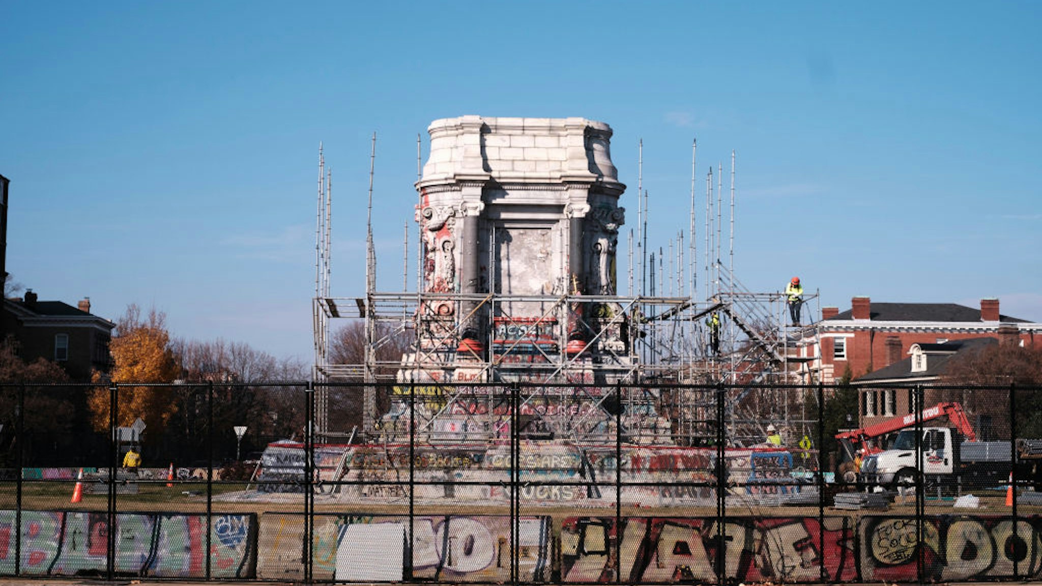 RICHMOND, VA - DECEMBER 06: Construction workers erect scaffolding around a pedestal as they prepare to dismantle it on December 6, 2021 in Richmond, Virginia. Governor Ralph Northam announced, on December 5th, that his administration will remove the pedestal that a statue of Robert E Lee once stood on. (Photo by Eze Amos/Getty Images)