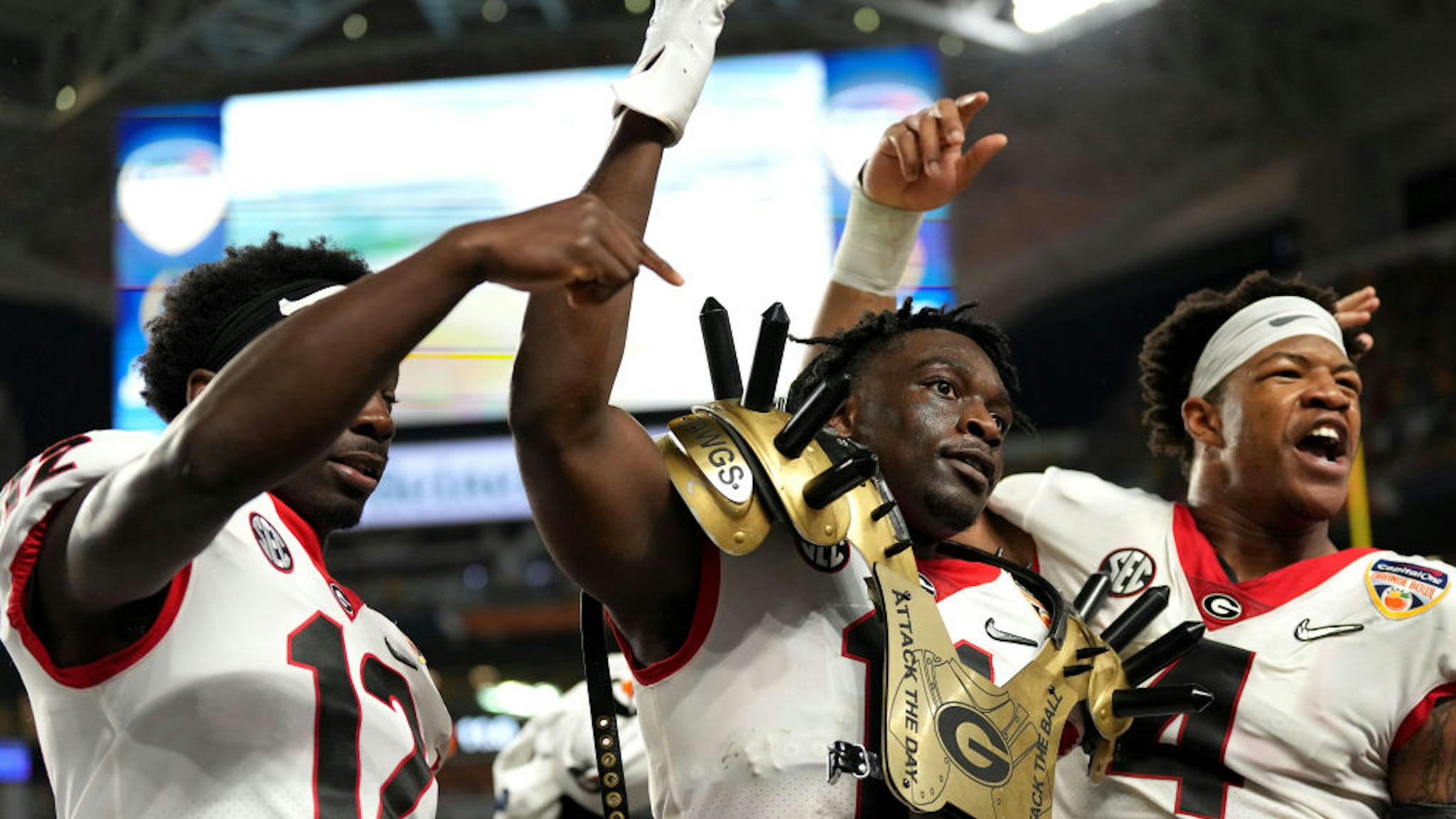 MIAMI GARDENS, FLORIDA - DECEMBER 31: Derion Kendrick #11 of the Georgia Bulldogs celebrates an interception with teammates, Nolan Smith #4 and Lovasea Carroll #12 of the Georgia Bulldogs in the third quarter of the game against the Michigan Wolverines in the Capital One Orange Bowl for the College Football Playoff semifinal game at Hard Rock Stadium on December 31, 2021 in Miami Gardens, Florida. (Photo by Mark Brown/Getty Images)