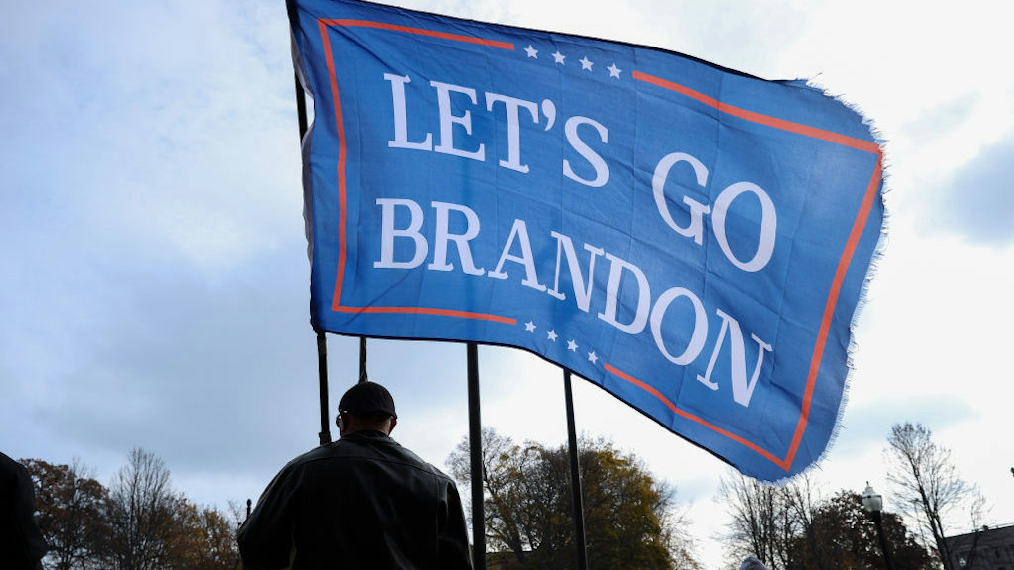 KENOSHA, WISCONSIN - NOVEMBER 16: A man flies a Lets Go Brandon flag as BLM protesters and Kyle Rittenhouse supporters are confronted outside of the Kenosha County Courthouse on closing arguments in the Kyle Rittenhouse trial in Kenosha, Wisconsin, United States on November 16, 2021. (Photo by Tayfun Coskun/Anadolu Agency via Getty Images)