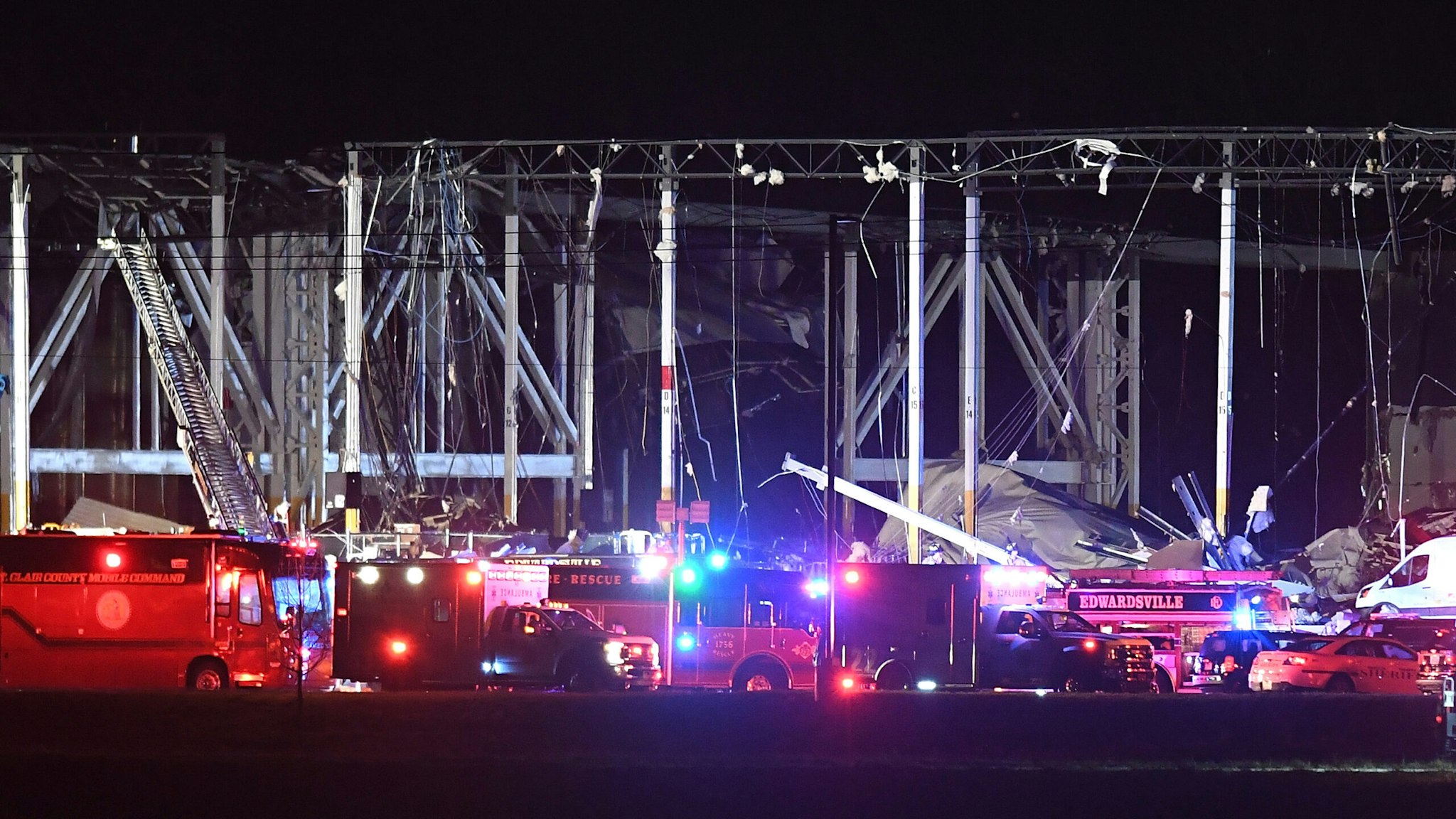 EDWARDSVILLE, IL - DECEMBER 10: First responders surround a damaged Amazon Distribution Center on December 10, 2021 in Edwardsville, Illinois. According to reports, the Distribution Center was struck by a tornado Friday night. Emergency vehicles arrived to start rescue operations for workers believed to be trapped inside.