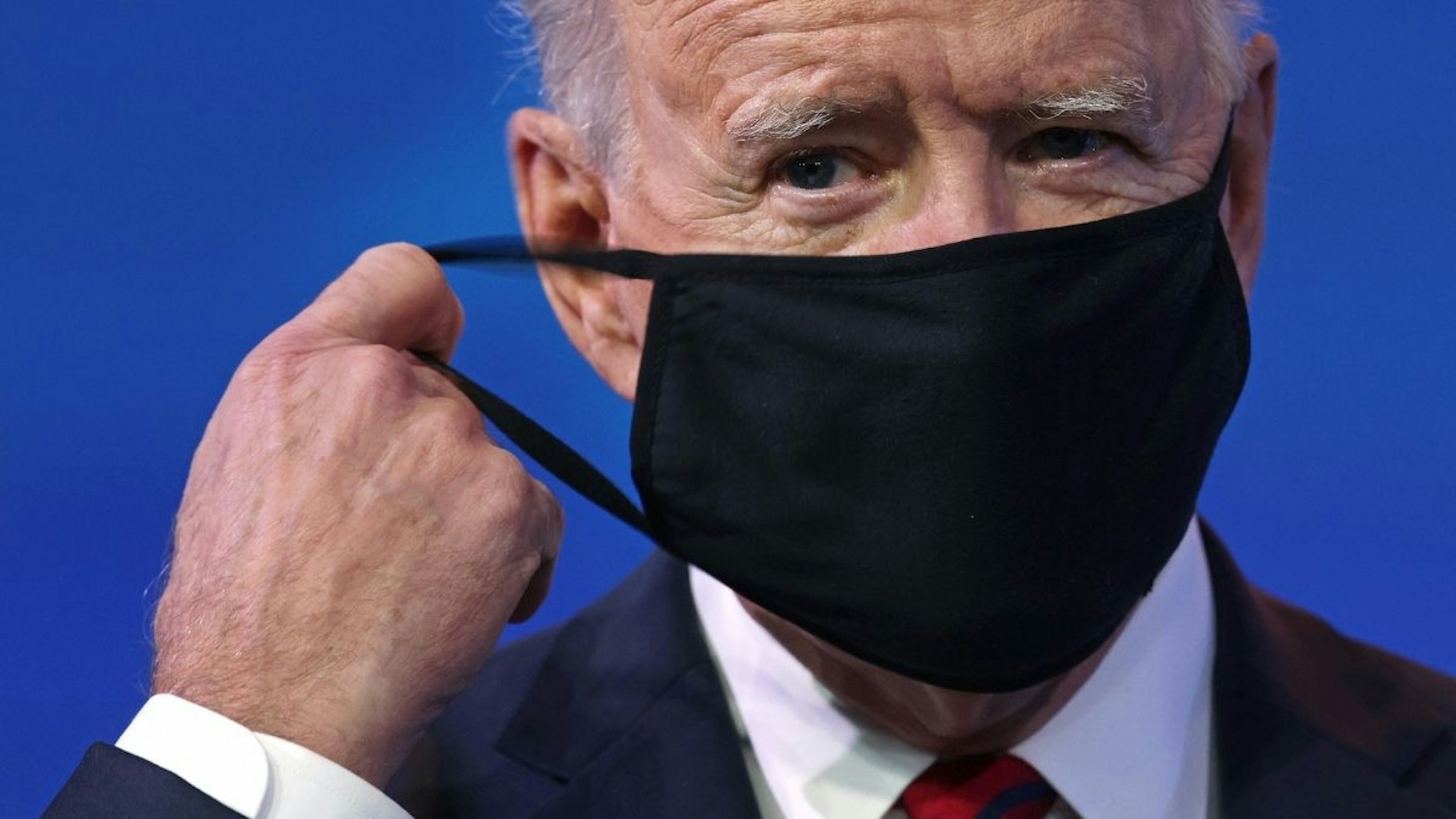 Then-U.S. President-elect Joe Biden takes off his mask as he arrives at the Queen theater to lay out his plan on combating the coronavirus January 15, 2021 in Wilmington, Delaware.