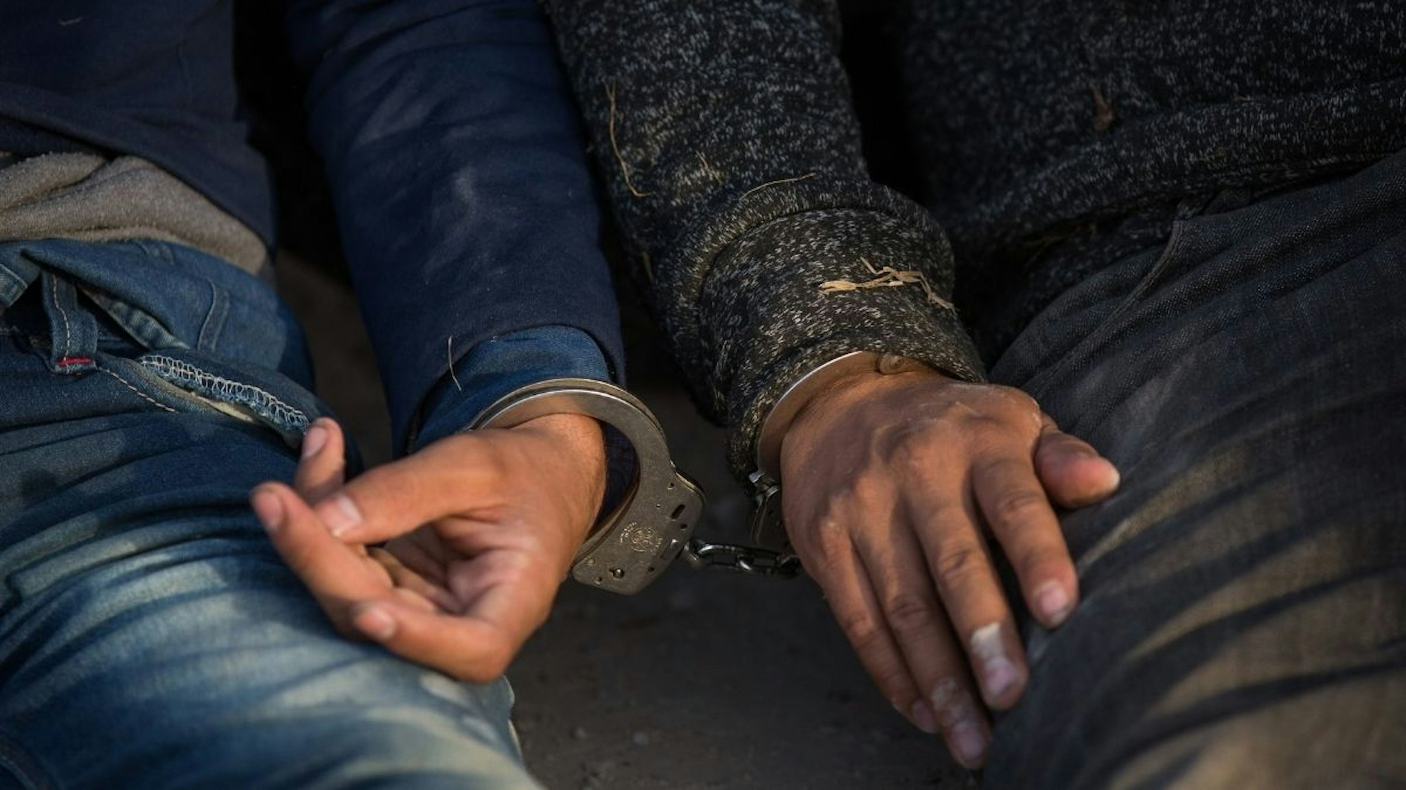 After being apprehended by Border Patrol, illegal immigrants wait to be transported to a central processing center shortly after they crossed the border from Mexico into the United States on Monday, March 26, 2018 in the Rio Grande Valley Sector near McAllen, Texas