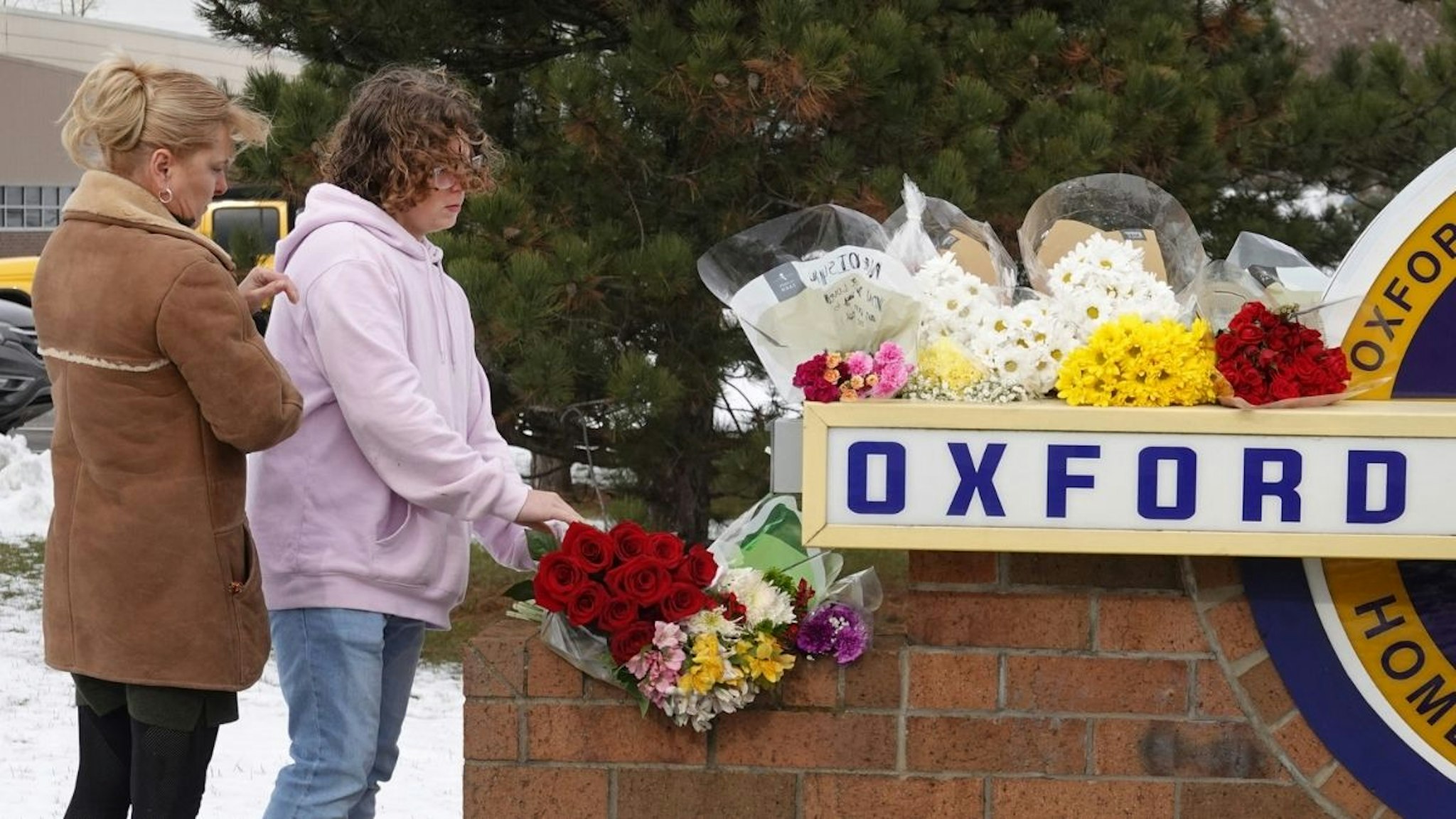 People bring flowers to a makeshift memorial outside of Oxford High School on December 01, 2021 in Oxford, Michigan. Y