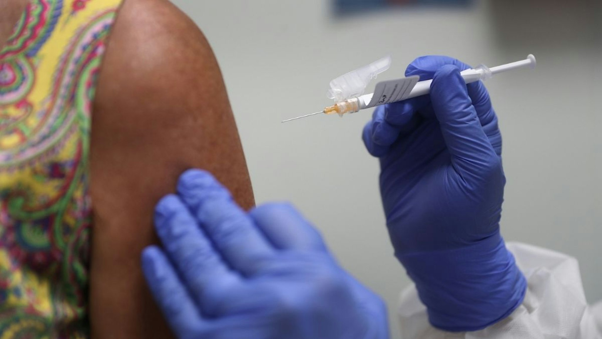 Lisa Taylor receives a COVID-19 vaccination from RN Jose Muniz as she takes part in a vaccine study at Research Centers of America on August 07, 2020 in Hollywood, Florida.