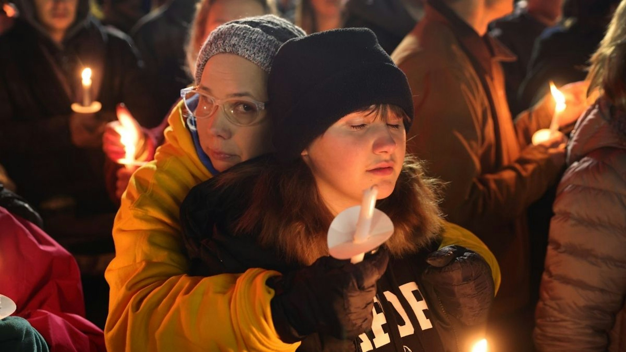 People attend a vigil downtown to honor those killed and wounded during the recent shooting at Oxford High School on December 03, 2021 in Oxford, Michigan.