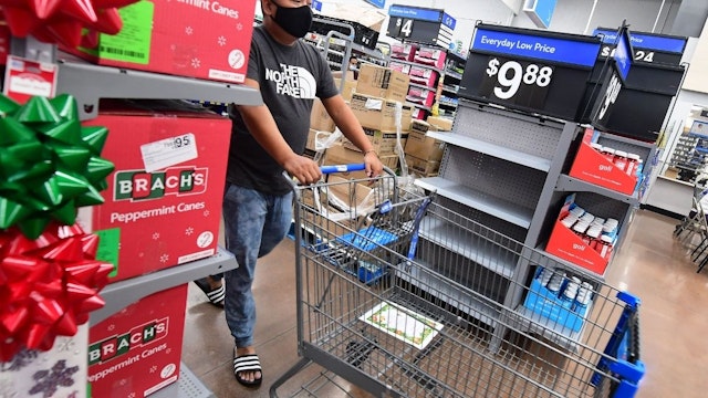People shop at a Walmart in Rosemead, California on November 22, 2021, where a few empty shelves were seen in an otherwise well stocked store amid improvements in the supply chain crisis for the end of year holiday season.