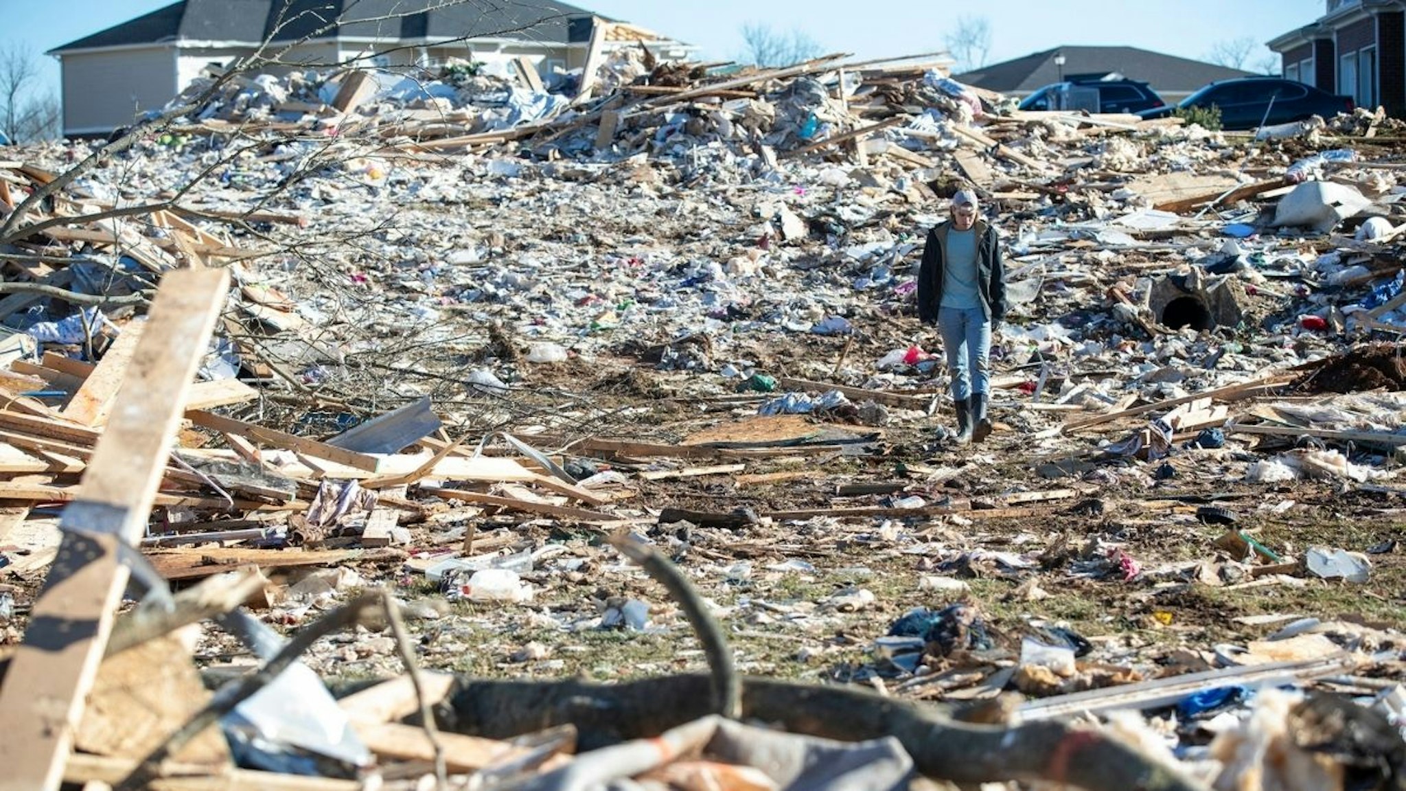 A man walks through the wrecked remains of houses in a neighborhood off Russellville Road after a tornado swept through Friday night in Bowling Green, Ky., Sunday, Dec. 12, 2021.