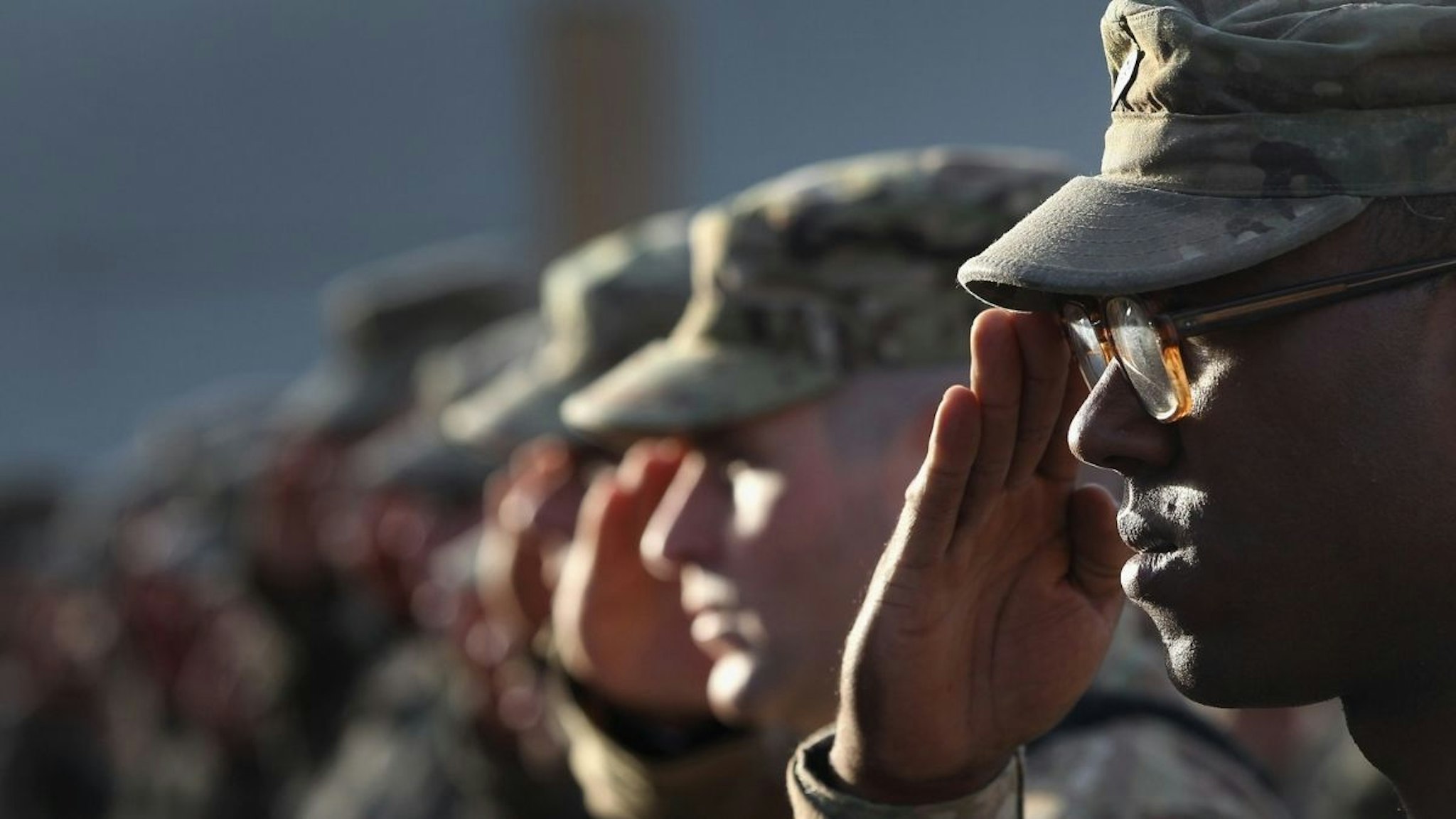 U.S. Army soldiers salute during the national anthem during the an anniversary ceremony of the terrorist attacks on September 11, 2001 on September 11, 2011 at Bagram Air Field, Afghanistan.