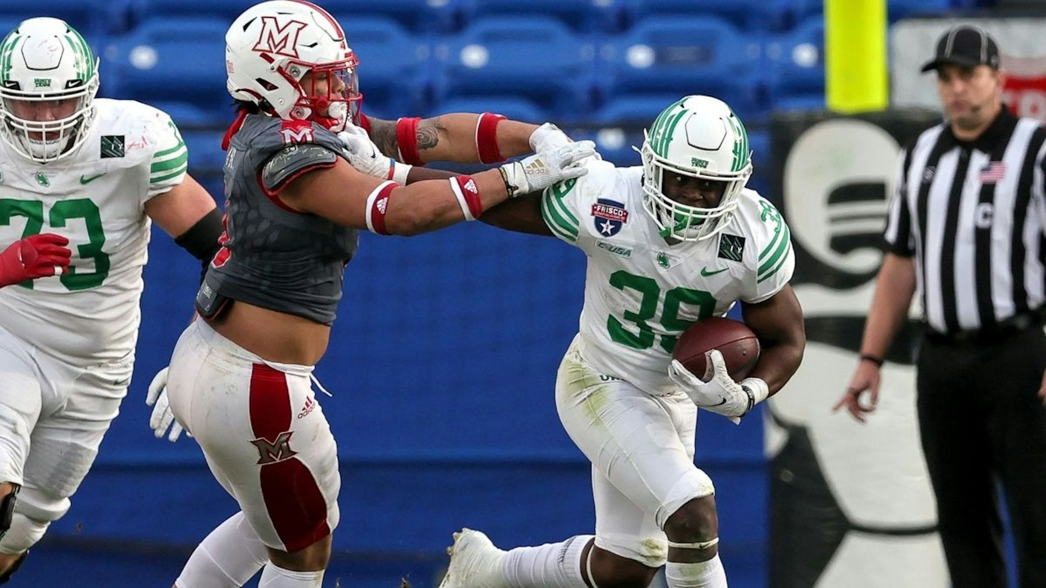 North Texas Mean Green running back Ayo Adeyi (39) gives a stiff arm to Miami (OH) Redhawks linebacker Ivan Pace Jr (L) during the Frisco Football Classic game between Miami (OH) Redhawks and North Texas Mean Green on December 23, 2021 at the Toyota Stadium in Frisco,Texas.