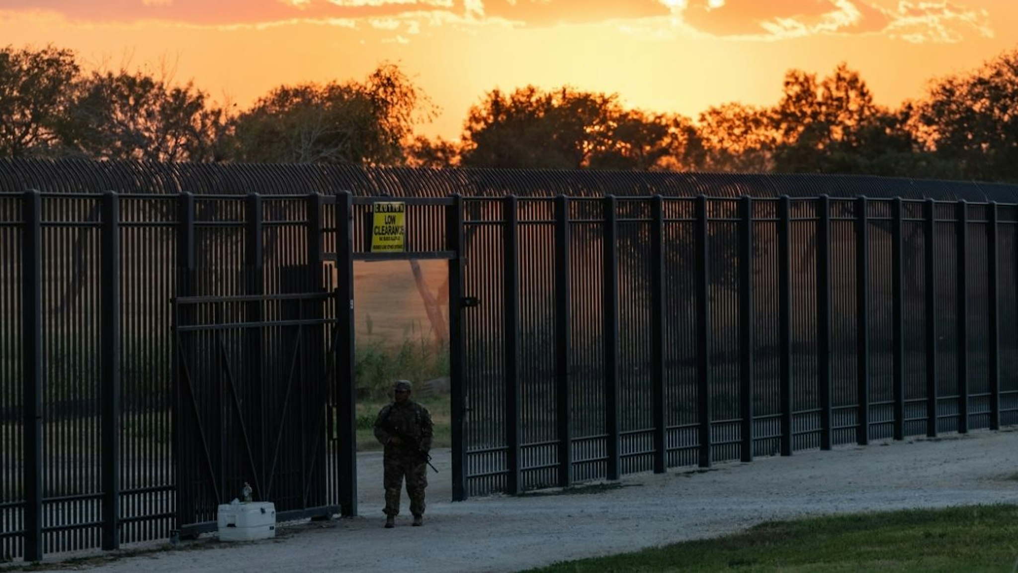 A Texas Army National Guard member guards an opening in the border wall near a makeshift migrant encampment where thousands of migrants have gathered, causing U.S. Customs and Border Protection to close the point of entry between the U.S. and Mexico in response to an influx of immigrants on September 17, 2021 in Del Rio, Texas.