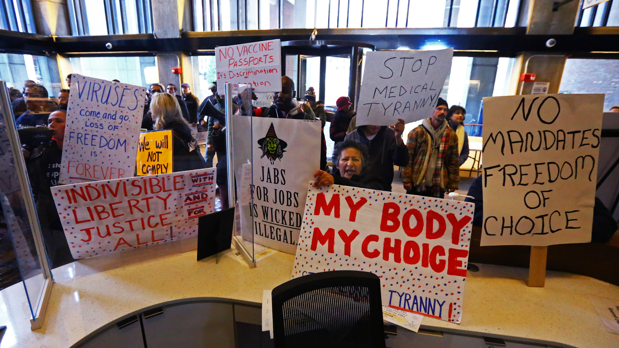 Protesters hold signs reading my body my choice, stop medical tyranny, and more, at Boston City Hall.
