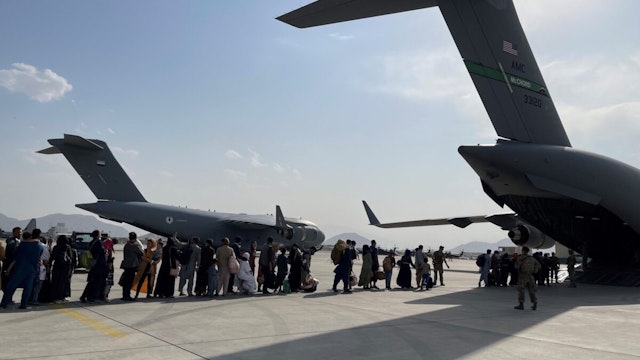 People queue up to board a military aircraft of the United States and leave Kabul at Kabul airport, Afghanistan, Aug. 22, 2021.