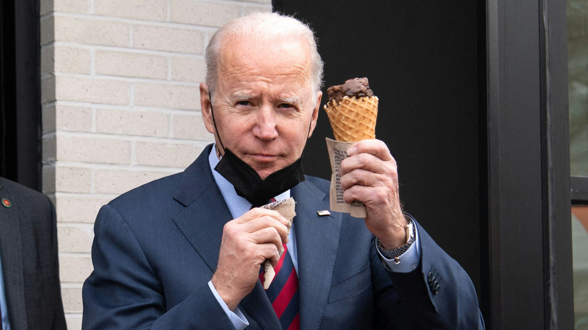 US President Joe Biden carries an ice cream cone as he leaves Jeni's Ice Cream in Washington, DC, on January 25, 2022.