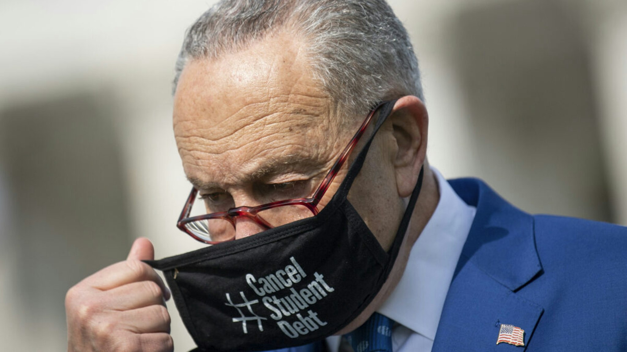 Senate Majority Leader Chuck Schumer, D-N.Y., wears a face mask that reads #CancelStudentDebt during a news conference about the Senate vote, later in the day, on methane regulation outside in Washington on Wednesday, April 28, 2021.