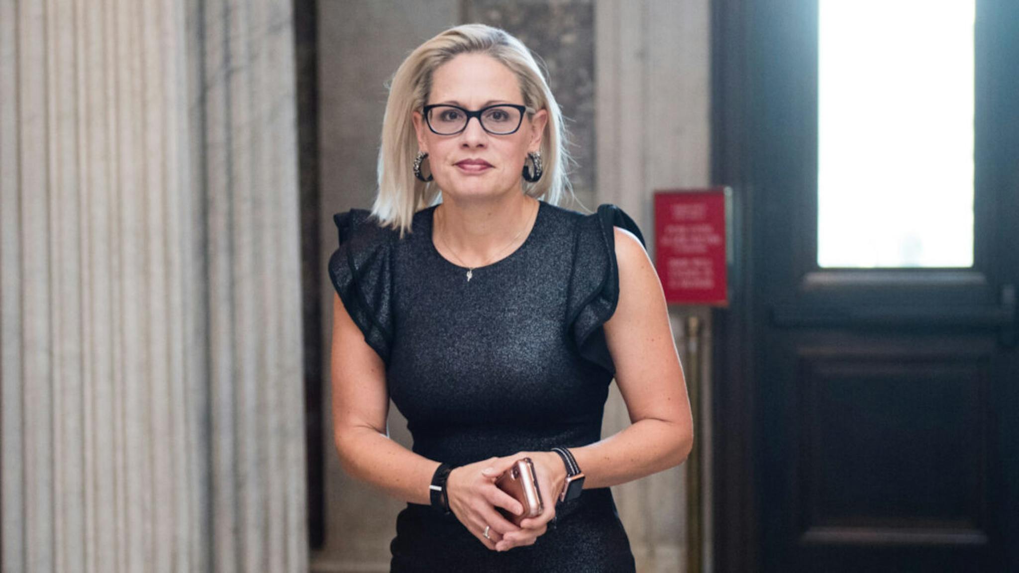 Sinema Sen. Kyrsten Sinema, D-Ariz., arrives for the votes in the Senate to keep the government open on Feb. 14, 2019.