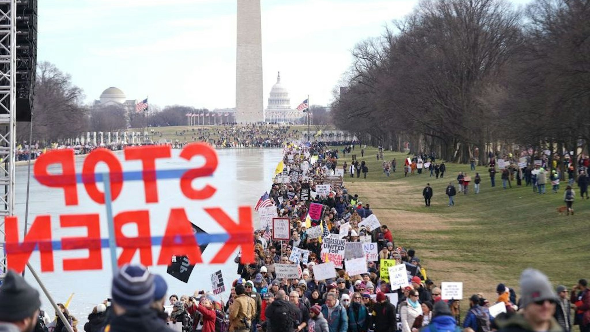 Demonstrators participate in a Defeat the Mandates march ate the Lincoln Memorial reflecting pool in Washington, DC, on January 23, 2022. - Demonstrators are protesting mask and Covid-19 vaccination mandates. (Photo by Stefani Reynolds / AFP) (Photo by STEFANI REYNOLDS/AFP via Getty Images)