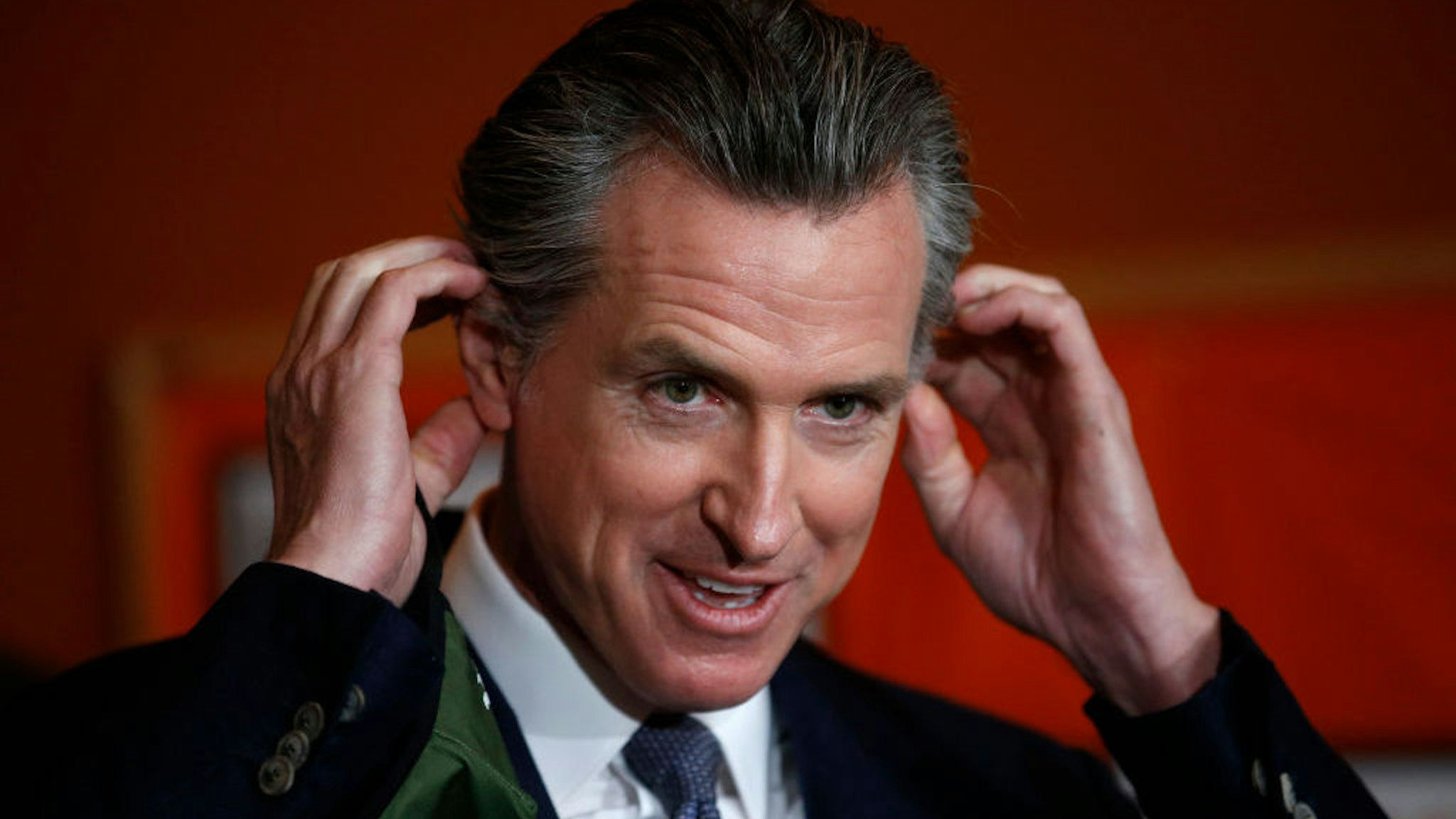 OAKLAND, CALIFORNIA - DECEMBER 22: Gov. Gavin Newsom removes his mask before speaking during a press conference at at the Native American Health Center in Oakland, Calif., on Wednesday, Dec. 22, 2021. (Jane Tyska/Digital First Media/East Bay Times via Getty Images)