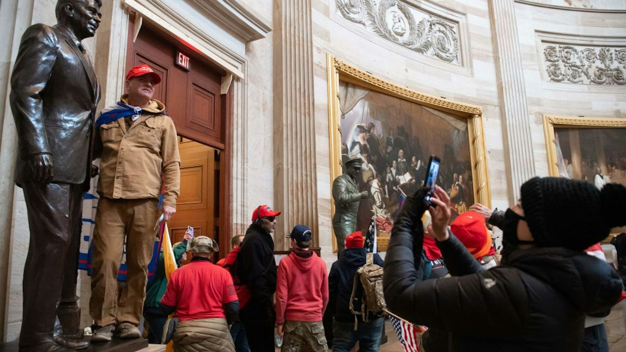 Supporters of US President Donald Trump pose with statues inside the Rotunda after breaching the US Capitol in Washington, DC, January 6, 2021.
