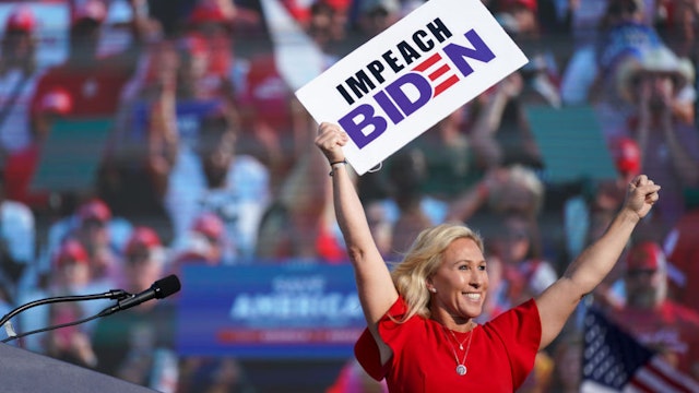 Rep. Marjorie Taylor Greene (R-GA) holds a sign that reads Impeach Biden at a rally featuring former US President Donald Trump on September 25, 2021 in Perry, Georgia.