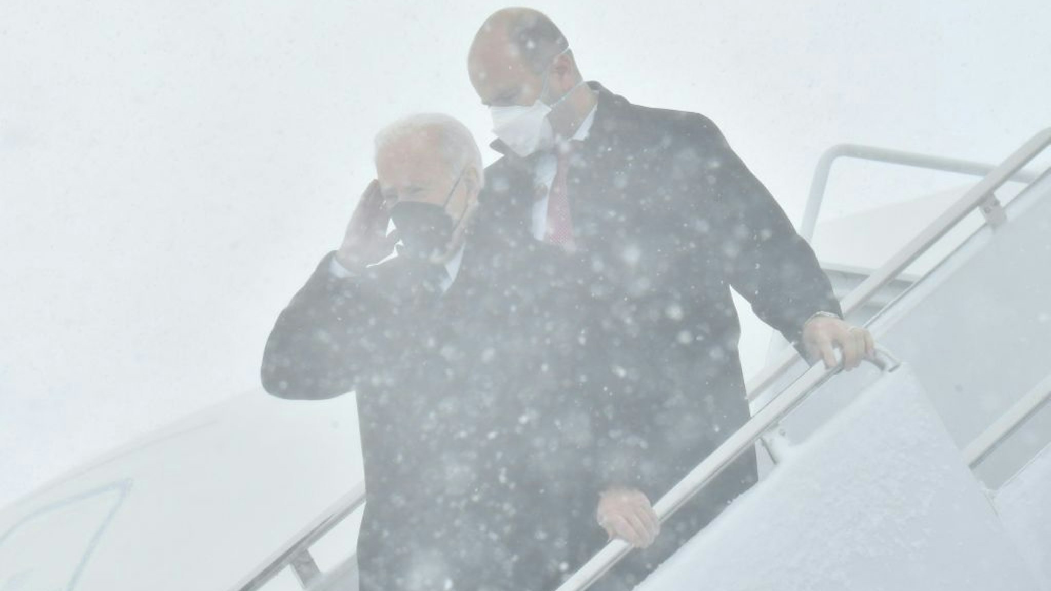 US President Joe Biden salutes as he disembarks from Air Force One during a snow storm upon arrival at Andrews Air Force Base January 3, 2022, in Maryland. (Photo by Nicholas Kamm / AFP) (Photo by NICHOLAS KAMM/AFP via Getty Images)