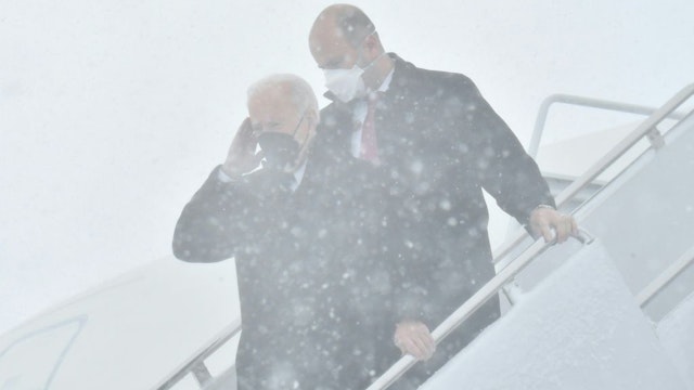 US President Joe Biden salutes as he disembarks from Air Force One during a snow storm upon arrival at Andrews Air Force Base January 3, 2022, in Maryland. (Photo by Nicholas Kamm / AFP) (Photo by NICHOLAS KAMM/AFP via Getty Images)