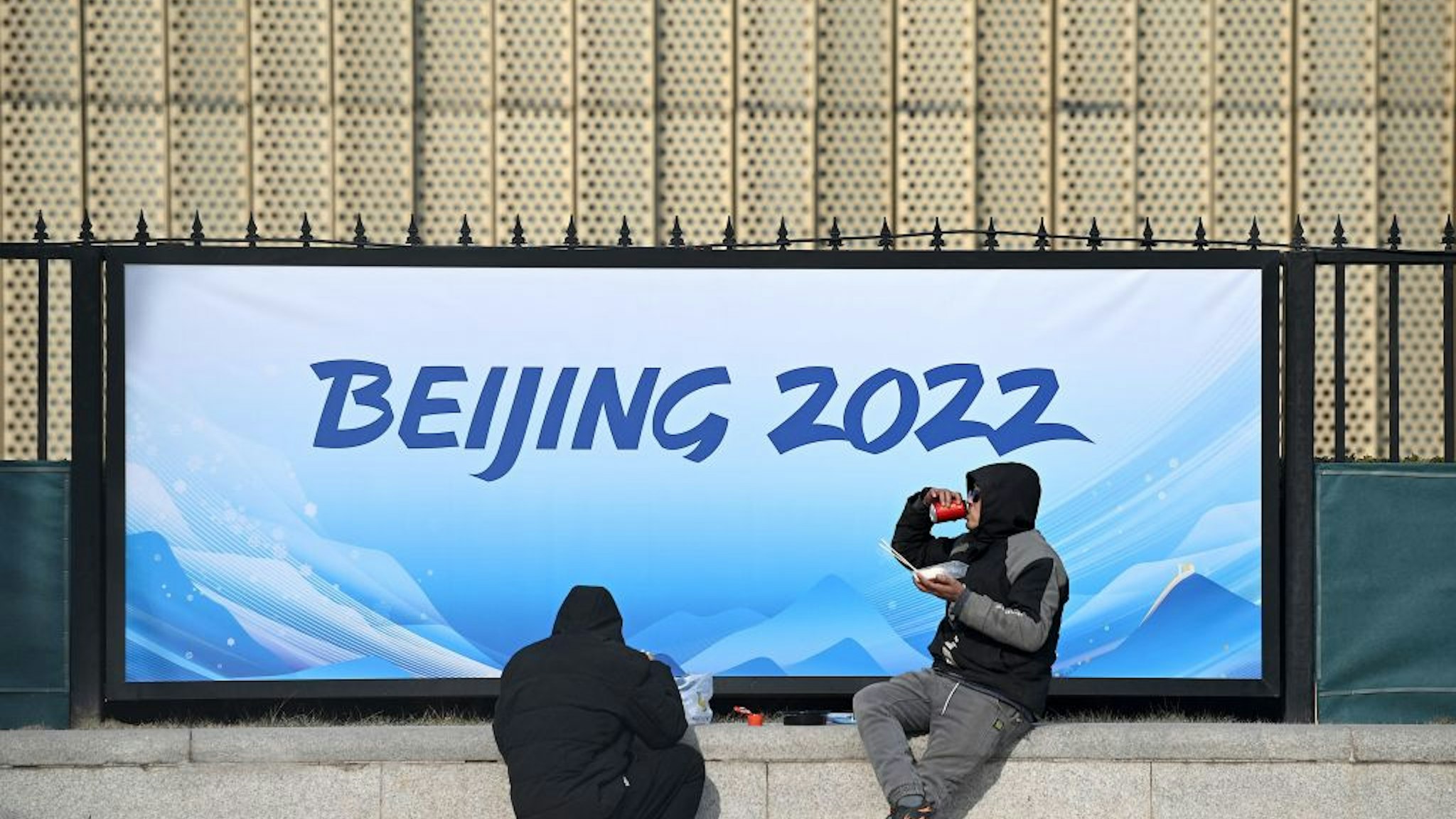 Workers eat at the Wukesong Sports Centre, venue for the ice hockey competition during the 2022 Beijing Winter Olympics, in Beijing on January 18, 2022.
