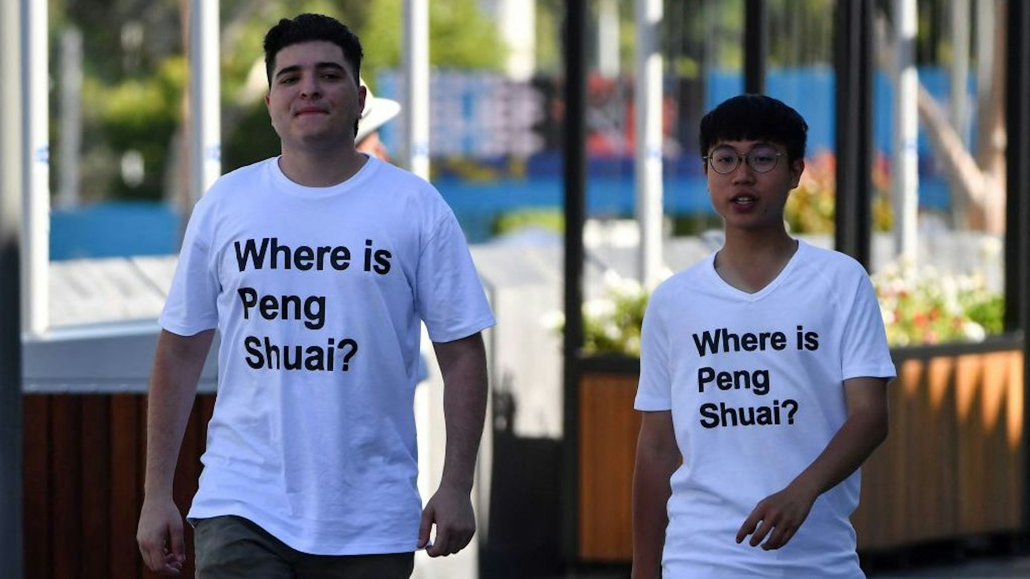 Australian human rights campaigner Drew Pavlou (L) is pictured wearing a "Where is Peng Shuai?" T-shirt, referring to the former doubles world number one from China, on the grounds outside one of the venues on day nine of the Australian Open tennis tournament in Melbourne on January 25, 2022. - -- IMAGE RESTRICTED TO EDITORIAL USE - STRICTLY NO COMMERCIAL USE -- (Photo by Paul Crock / AFP) / -- IMAGE RESTRICTED TO EDITORIAL USE - STRICTLY NO COMMERCIAL USE -- (Photo by PAUL CROCK/AFP via Getty Images)